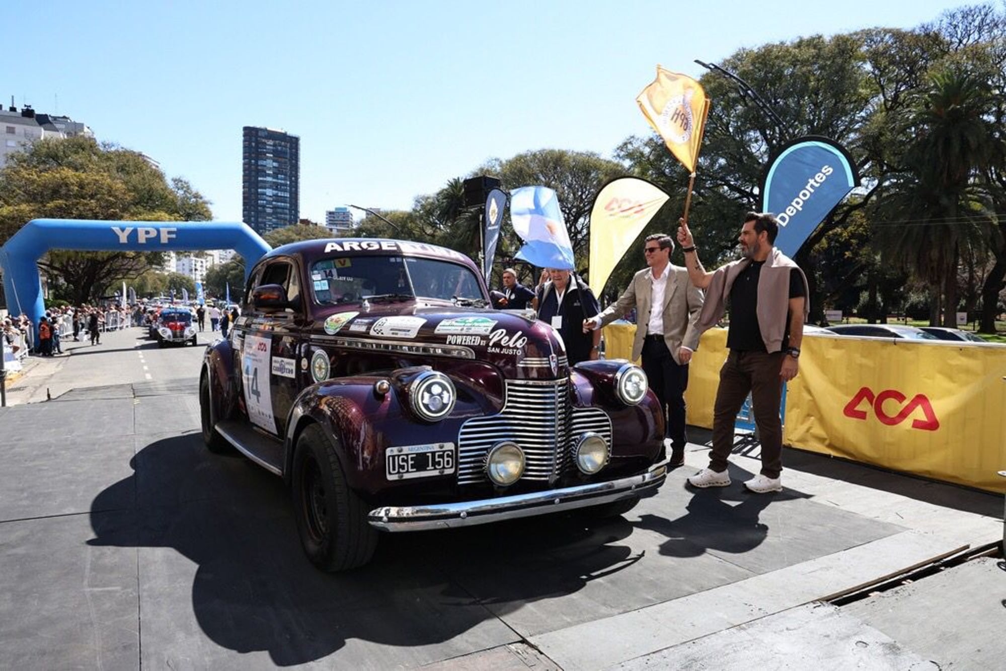El vehículo más imponente del Gran Premio Argentino Histórico empieza su participación en Buenos Aires con la bajada de la bandera argentina por parte de César Carman (n.), presidente de Automóvil Club Argentino; a la izquierda, Jorge E. Revello, vicepresidente segundo de la entidad y principal organizador de la competencia.