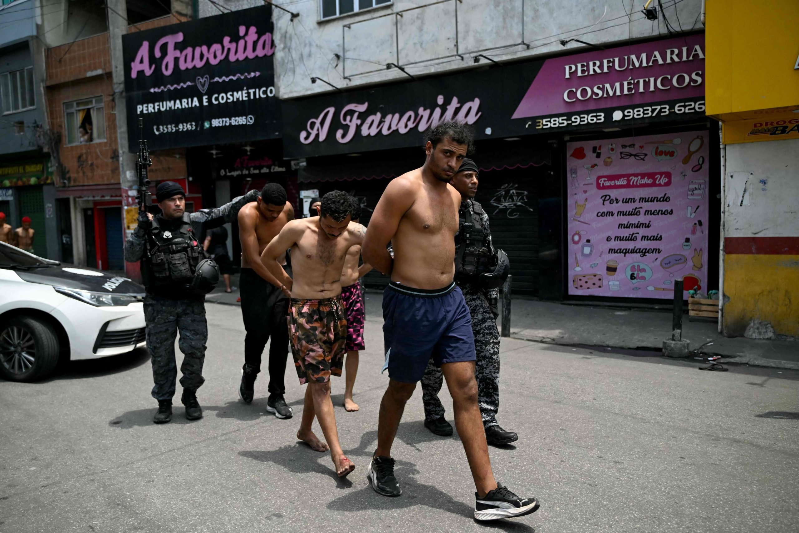Agentes de policía escoltan a sospechosos arrestados durante la Operación Contención fuera de la favela Vila Cruzeiro, en el complejo Penha, Río de Janeiro, Brasil
