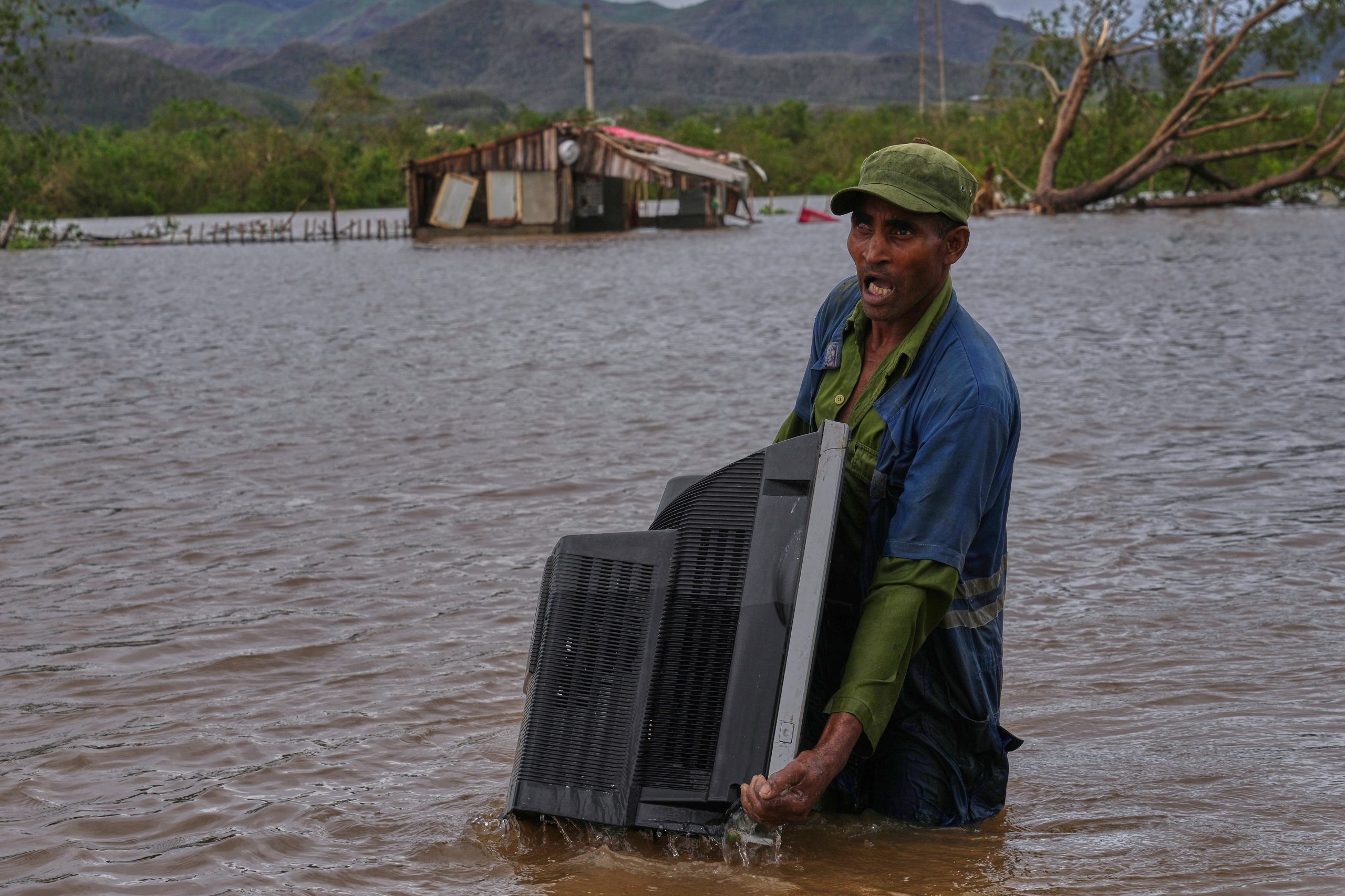 Un hombre carga con un televisor que sacó de su casa, inundada tras el paso del huracán Melissa, en Santiago de Cuba. (Foto: AP/Ramón Espinosa).