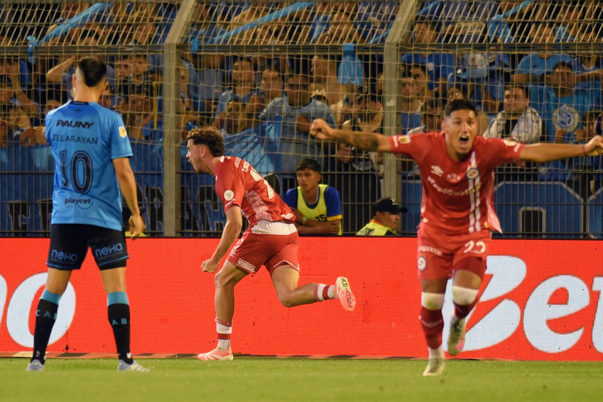 Tomás Molina acaba de convertir el penal con el que Argentinos Juniors revierte el resultado frente a Belgrano y gana en Rosario su semifinal por Copa Argentina; festeja también Leandro Lozano.
