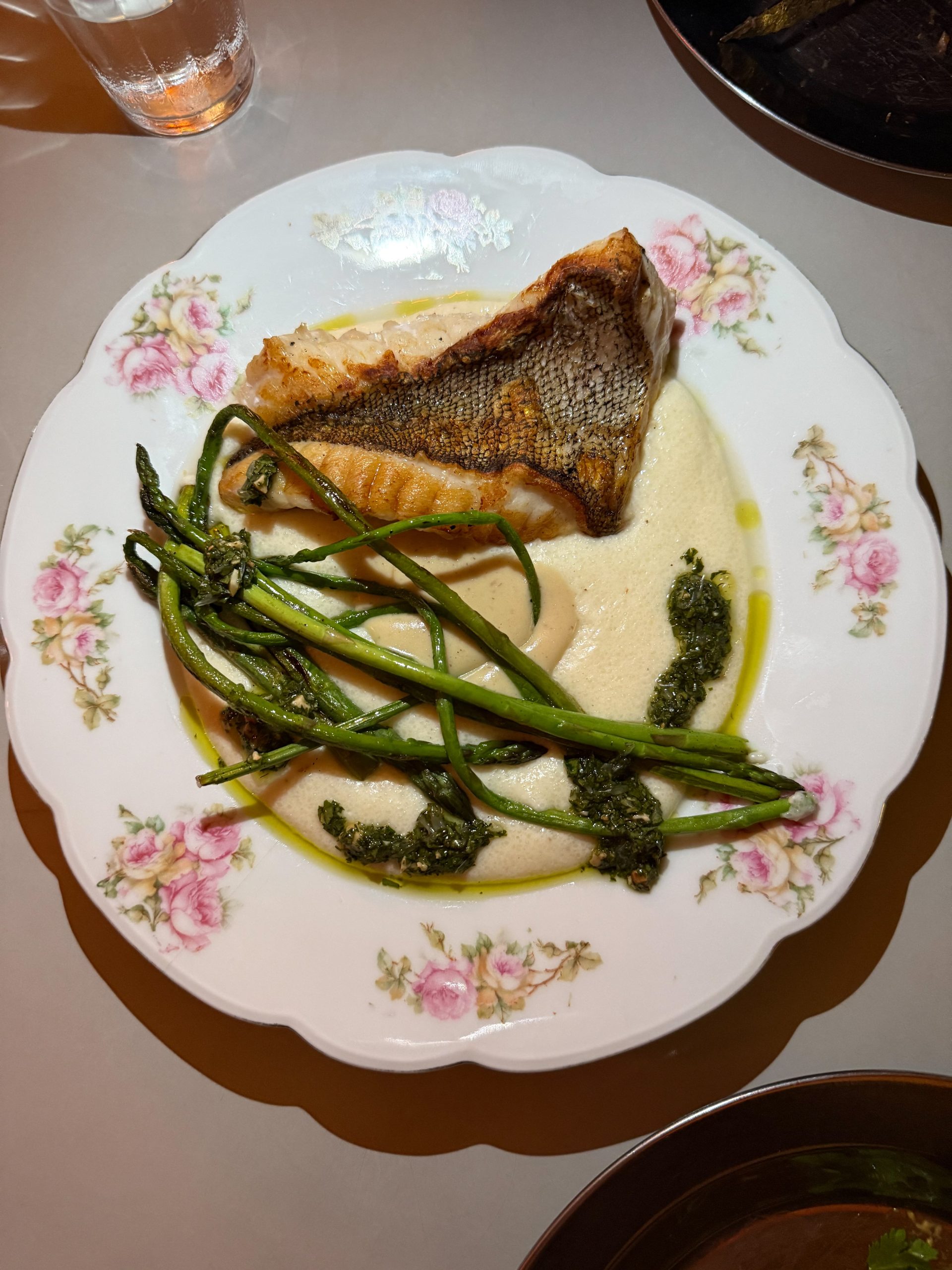 La chernia se sirve con polenta blanca, espárragos y gremolata