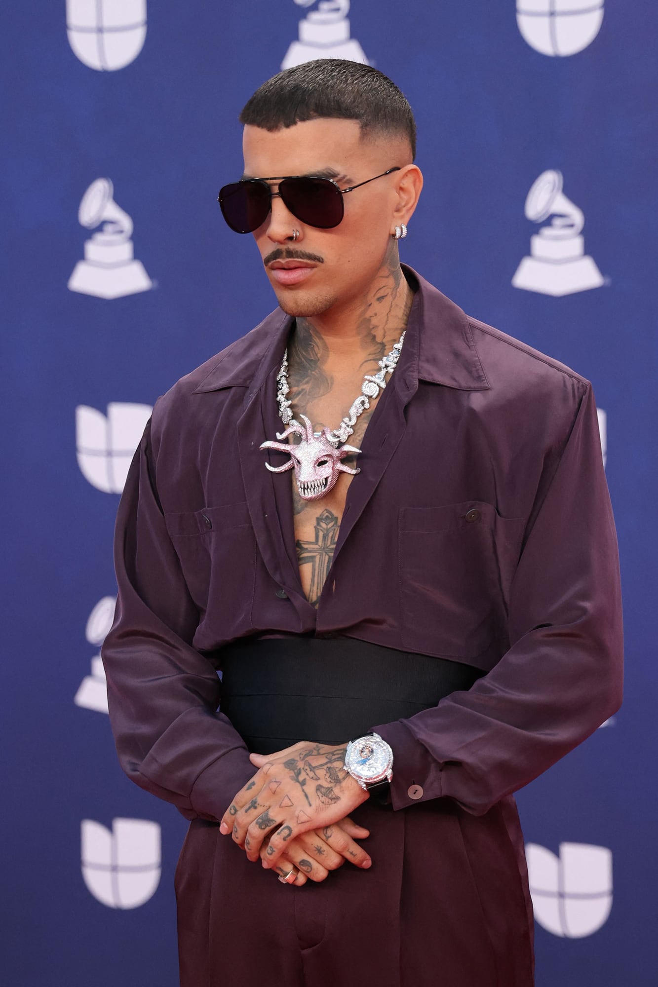 El puertorriqueño Rauw Alejandro marcó tendencia con un conjunto en color violeta. La faja negra y el exuberante colgante lo convirtieron en uno de los más osados de la fiesta