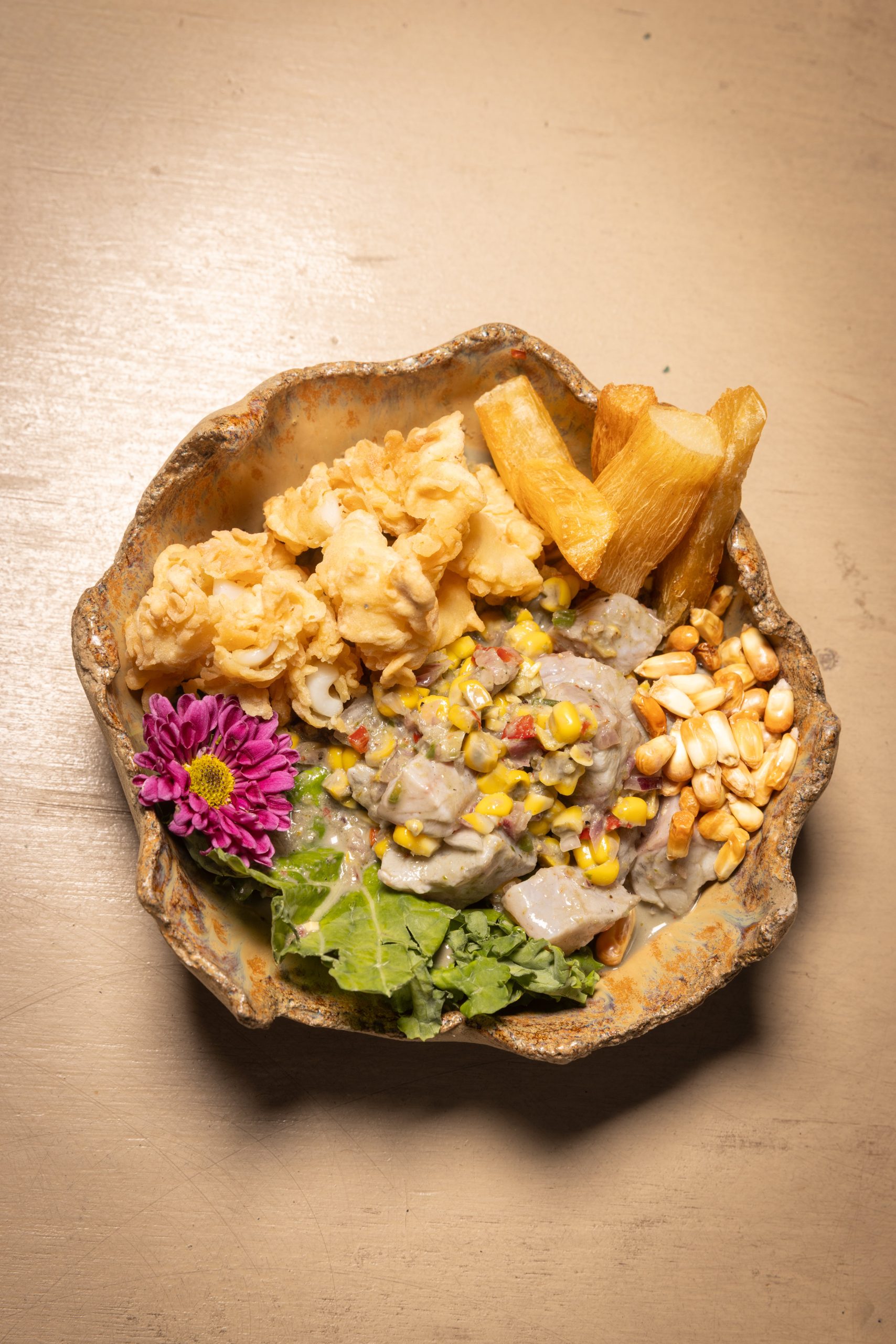 Ceviche Ñuro con mero macerado en leche de tigre y tinta de sepia, coronado con chipirones crocantes y maíz mote