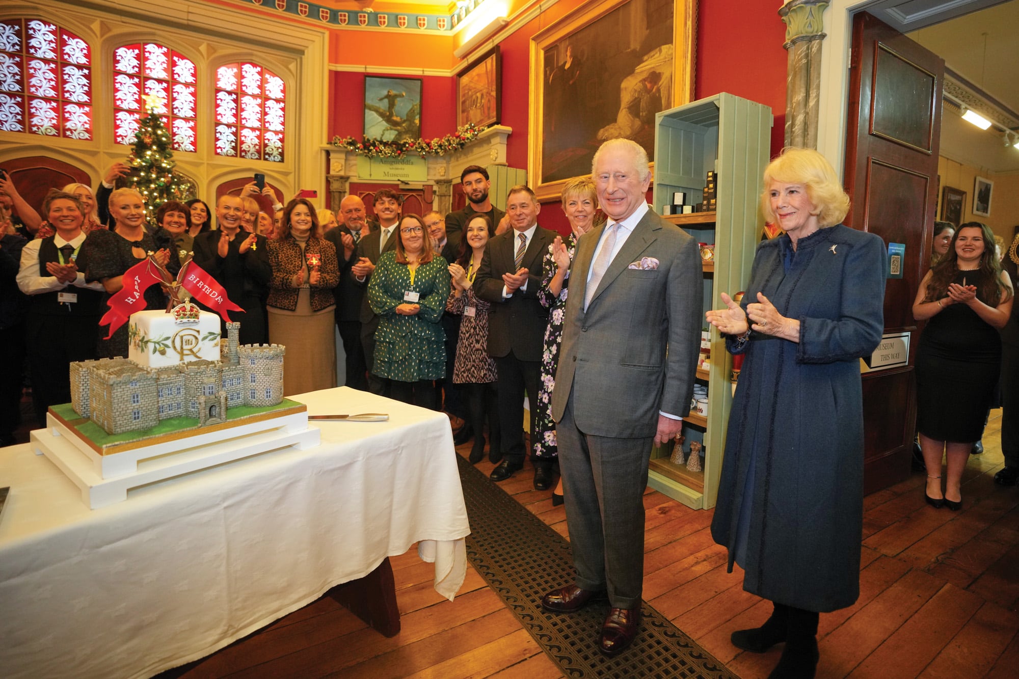 Para acompañar a su marido en su día especial, la Reina eligió un diseño de la británica Anna Valentine que ya había usado en otras ocasiones, al igual que los guantes de cuero –de Sermoneta Gloves–, las botas altas –de Russell and Bromley– y el broche con forma de puerro, que perteneció a Isabel II