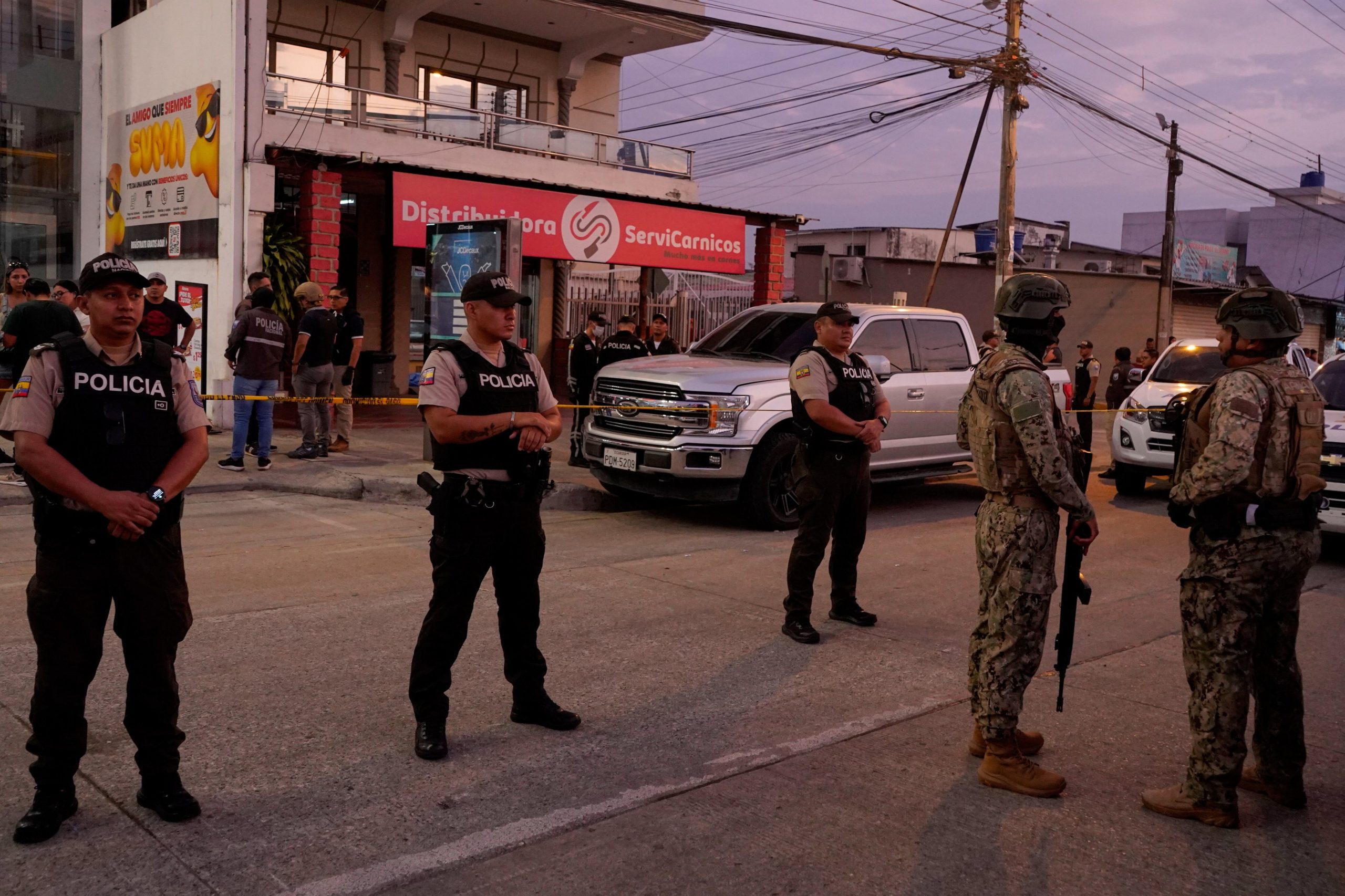 Police stand guard near the body of slain soccer player Mario Pineida at a butcher shop in Guayaquil, Ecuador, Wednesday, Dec. 17, 2025. (AP Photo/Cesar Munoz)