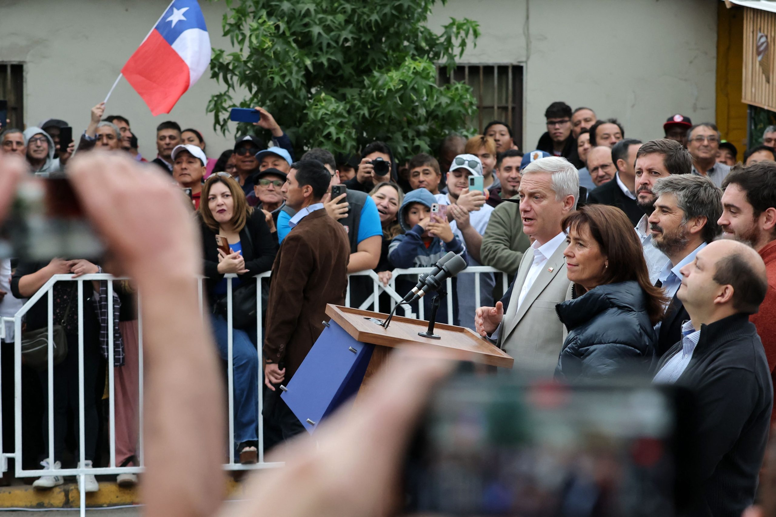 El candidato presidencial chileno José Antonio Kast, del Partido Republicano, habla junto a su esposa, María Pía Adriasola, afuera de un local de votación tras emitir su voto.