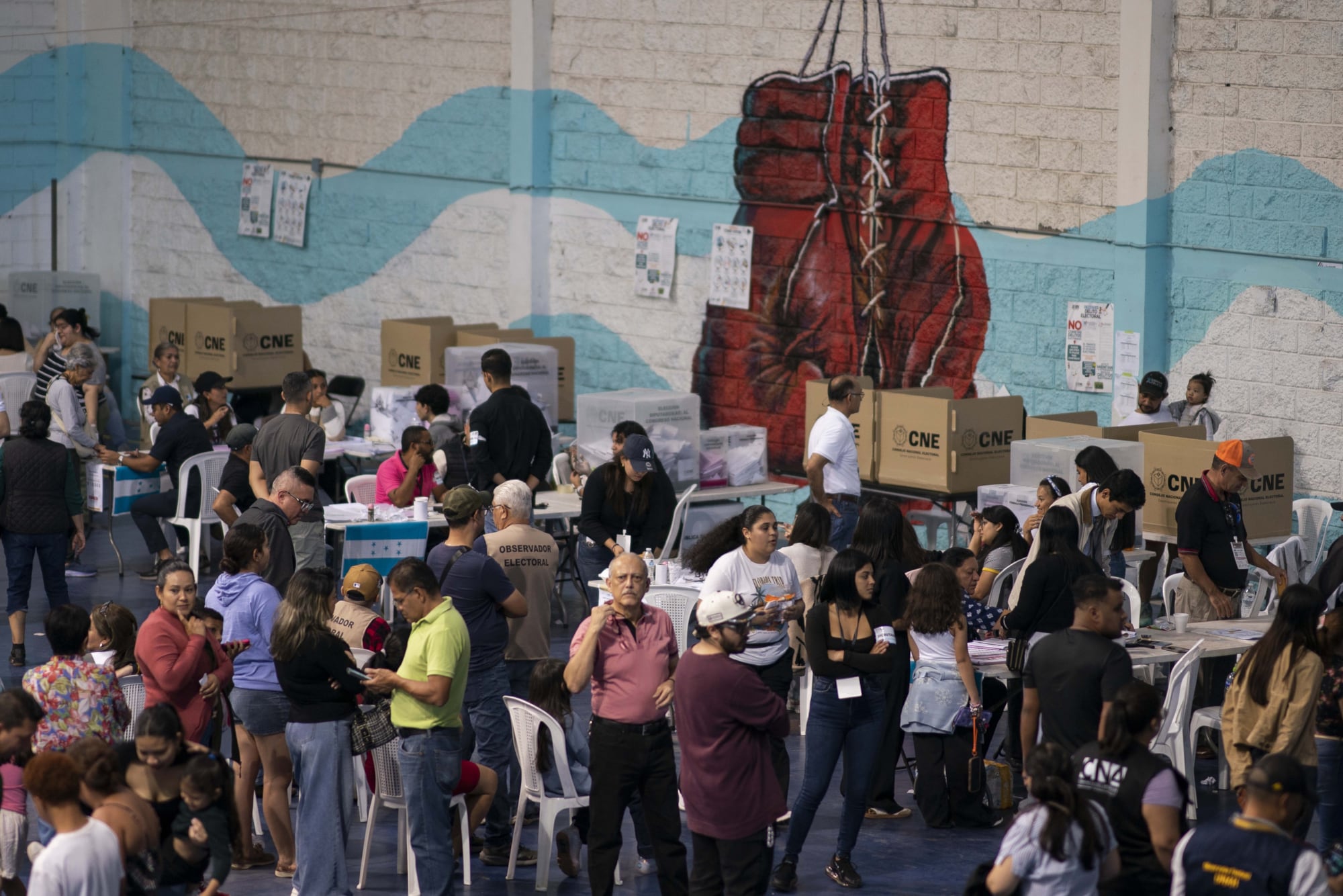 Personas esperan para emitir su voto en un colegio electoral