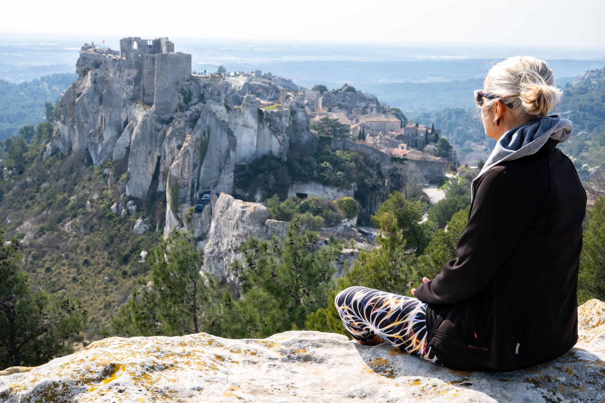 Mujer mirando el pueblo de Les Baux de Provence durante la primavera