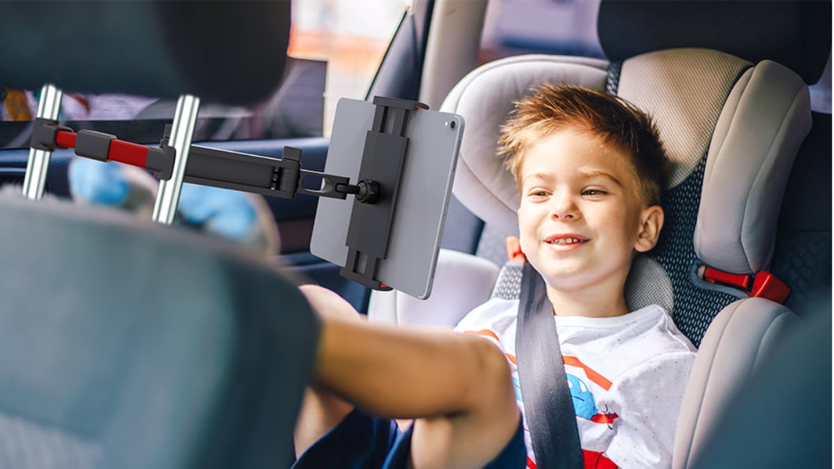 Niño en su asiento infantil viendo una ‘tablet’ durante un viaje en coche.