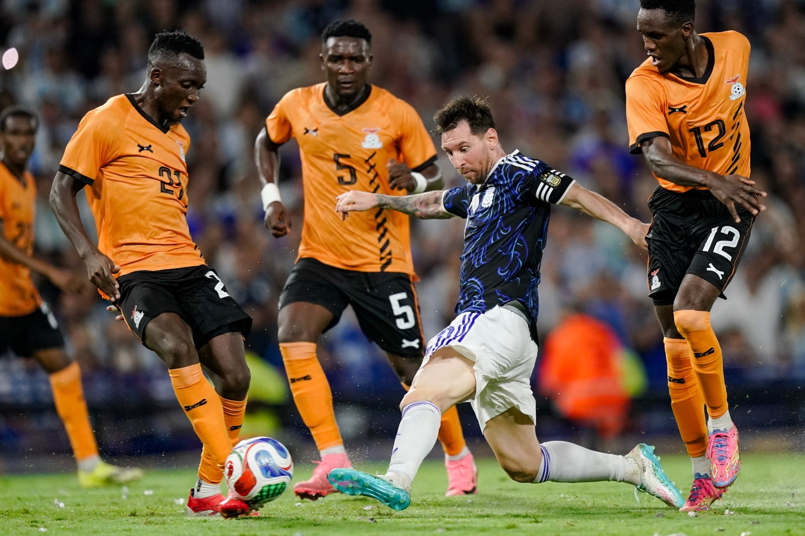 Messi y la pelota, entre tres defensores de Zambia