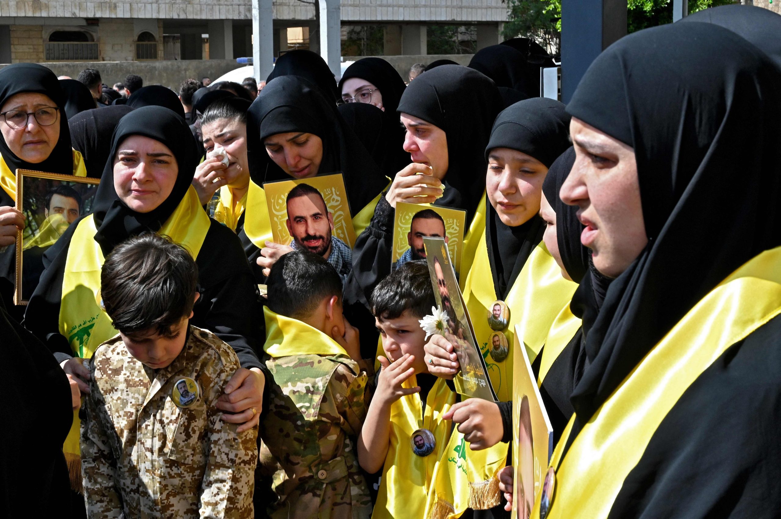 Los dolientes sostienen retratos de miembros del grupo militante Hezbollah, respaldado por Irán, que murieron en el sur del Líbano durante su funeral en el área de Kafaat en los suburbios del sur de Beirut el 20 de abril de 2026