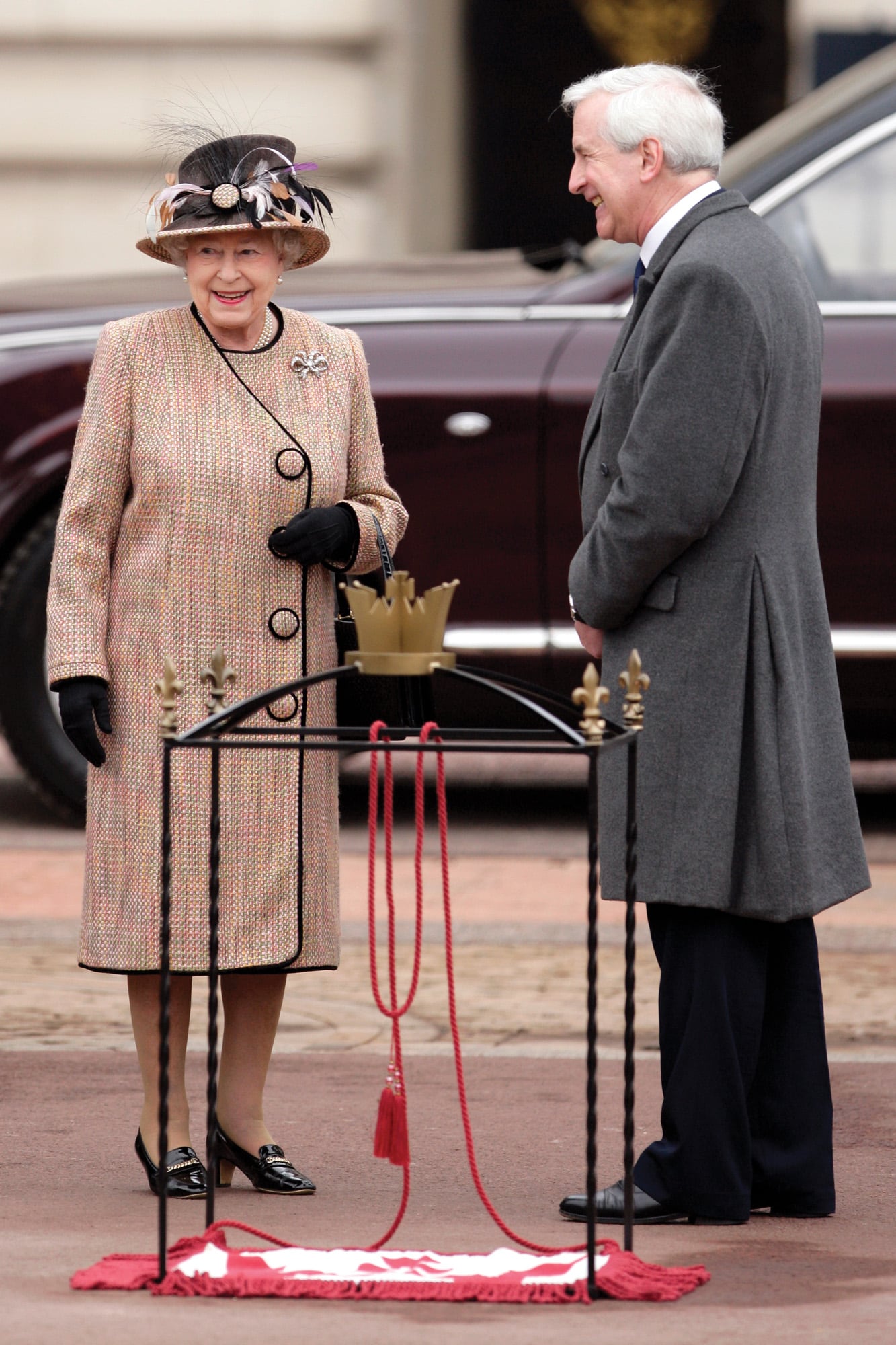 La soberana conversa con el autor del libro, Hugo Vickers, en un acto celebrado en Londres en febrero de 2012