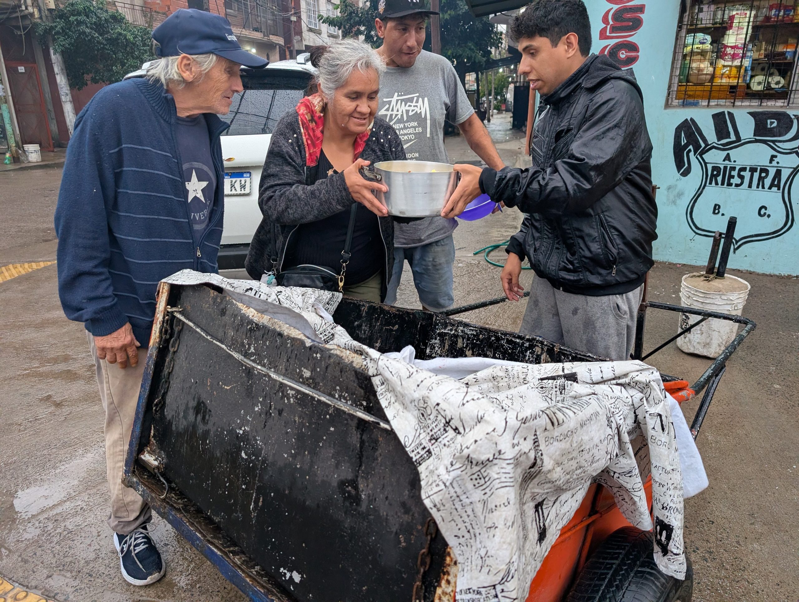 Los vecinos ya conocen a Natanael y se acercan a charlar con él mientras les sirve un plato de comida