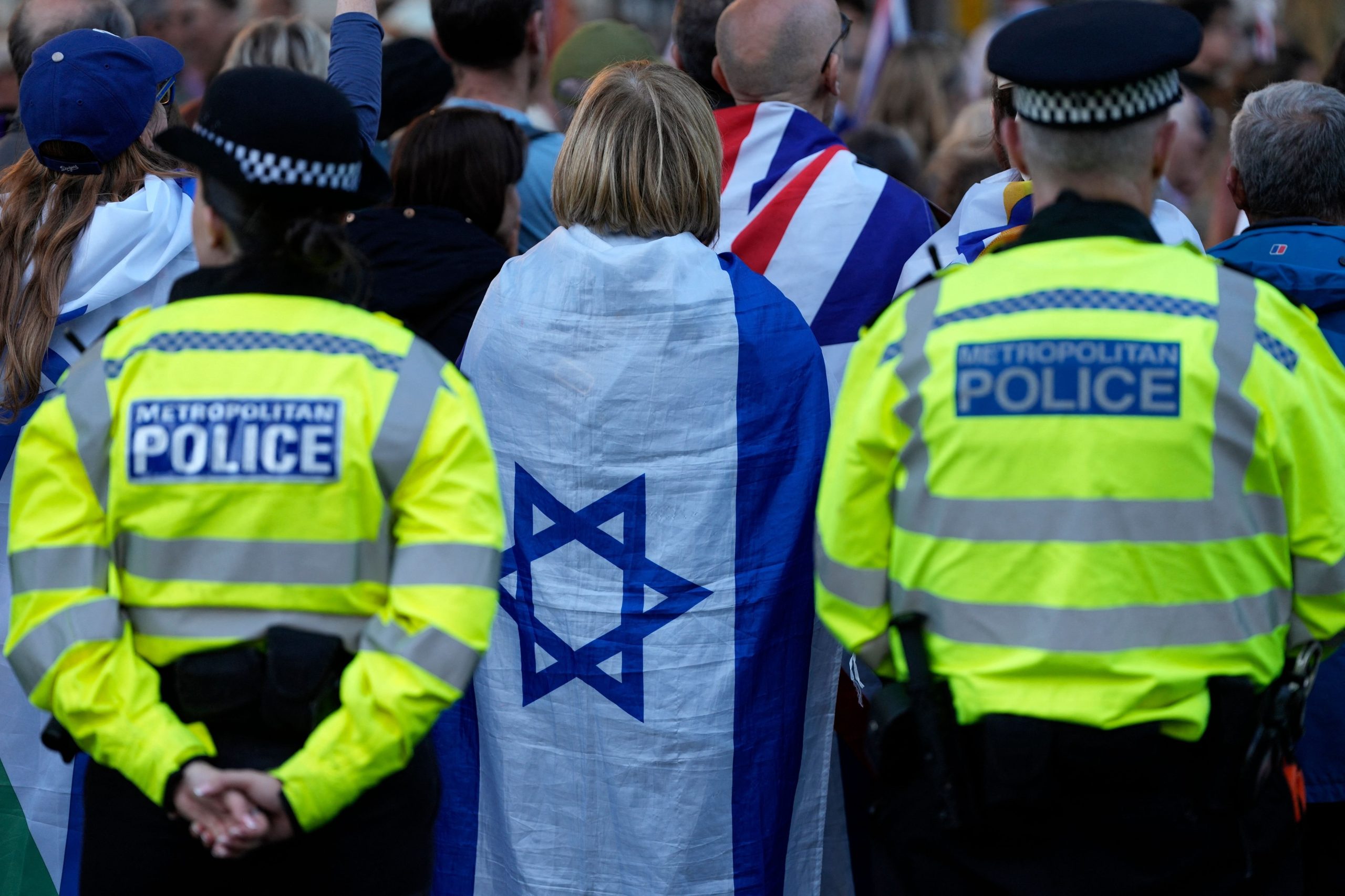 Agentes de la Policía Metropolitana permanecen de guardia mientras personas asisten a una manifestación organizada por la Campaña contra el Antisemitismo, frente a Downing Street, en el centro de Londres