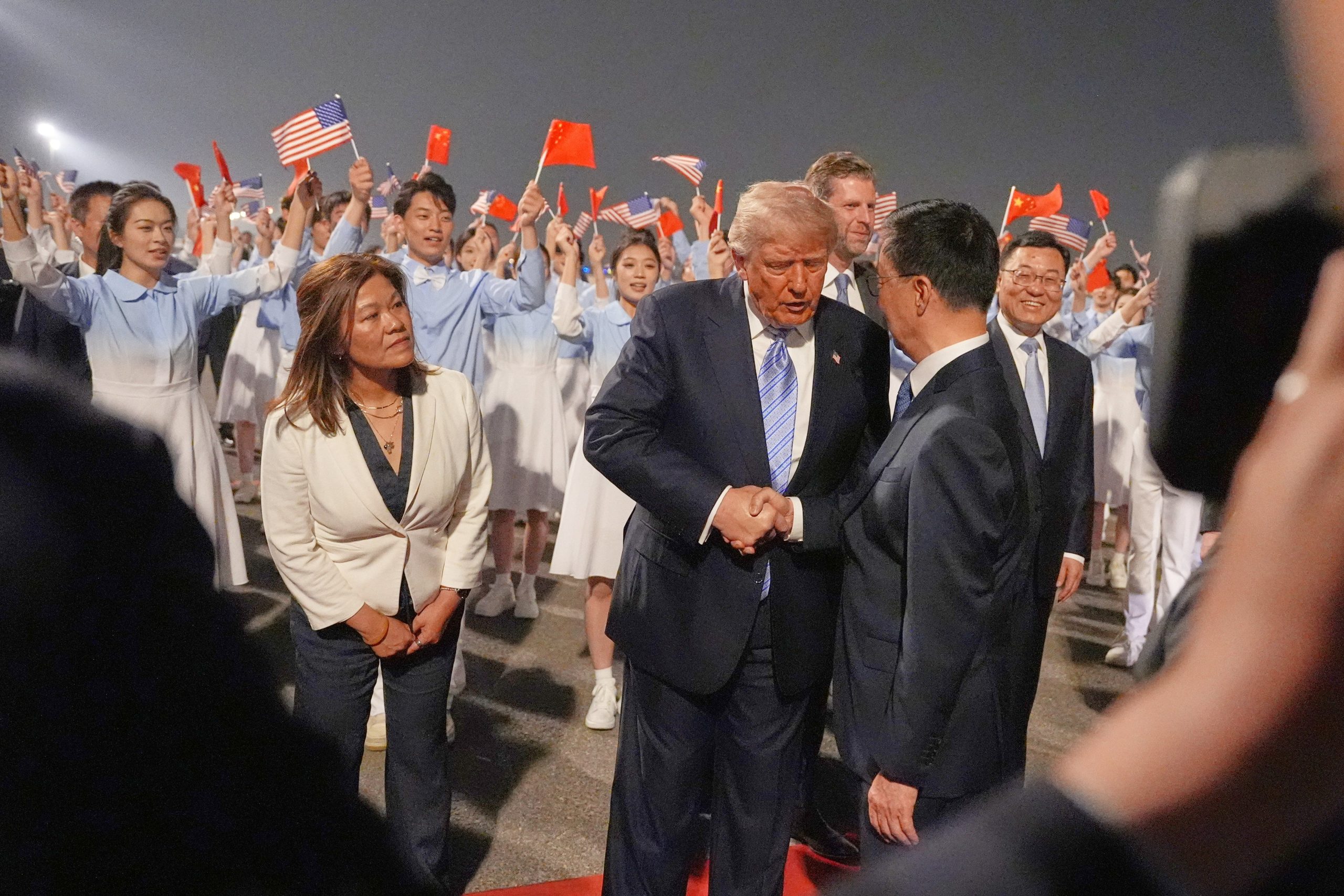 El presidente Donald Trump estrecha la mano durante una ceremonia de bienvenida el miércoles 13 de mayo de 2026 en el Aeropuerto Internacional de Pekín-Capital
