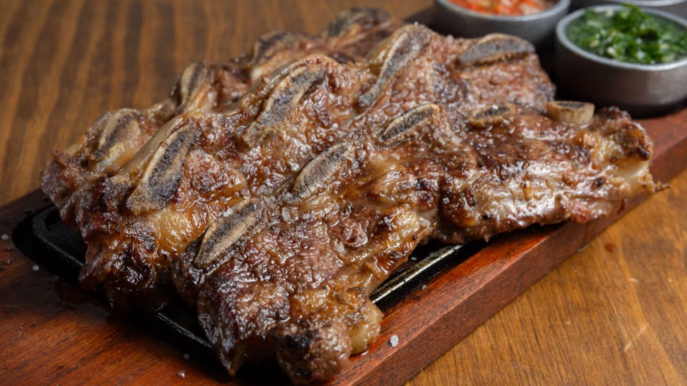 Asado de tira cocido y presentado en una tabla. (Foto: Adobe Stock)