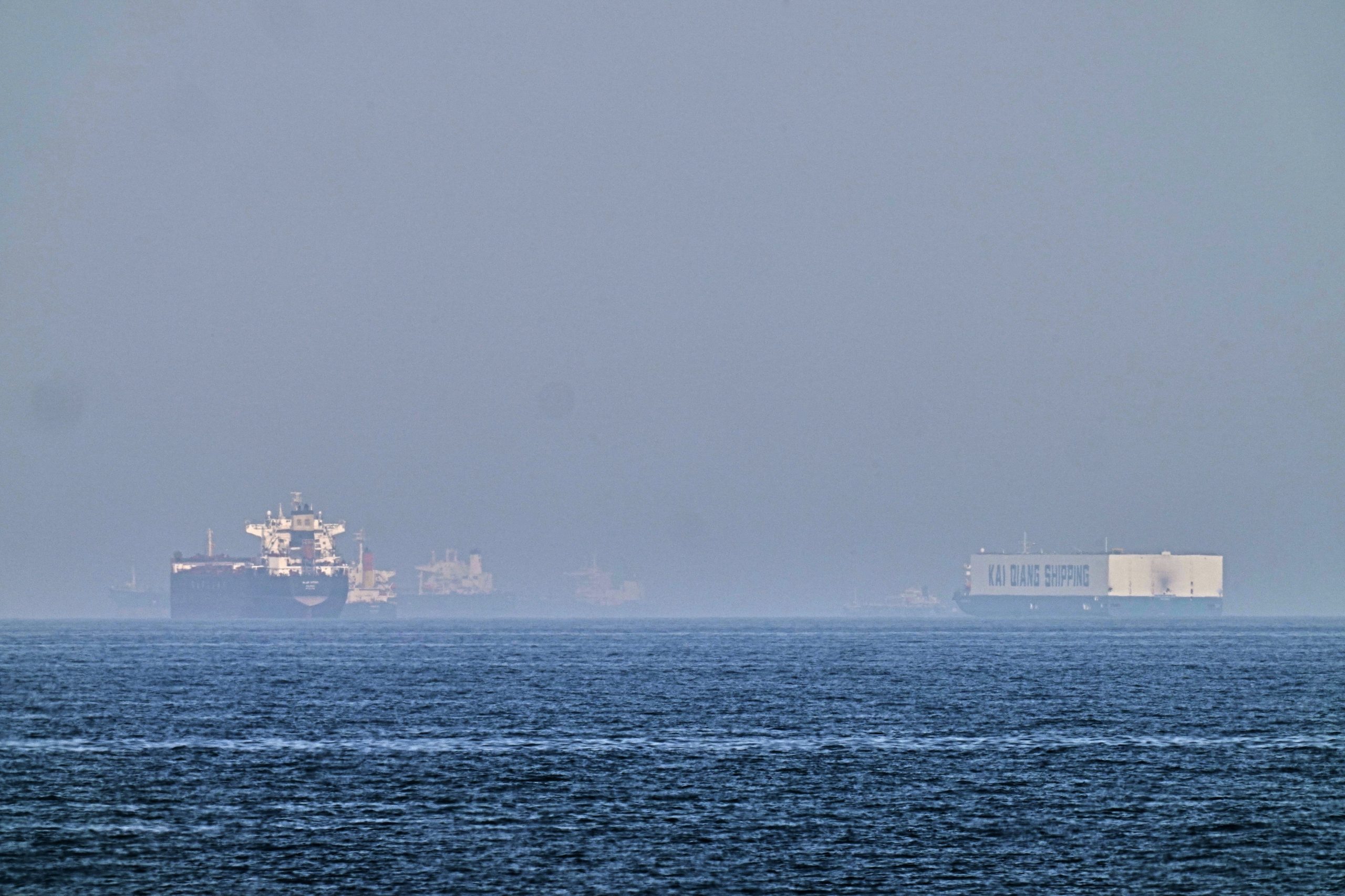 Un petrolero (izquierda) y un barco con autos, fondeados en el golfo de Omán, cerca del estrecho de Ormuz, vistos desde las costas de Khor Fakkan, Emiratos Árabes Unidos, el 1 de mayo de  2026. (AP Foto/Fatima Shbair)