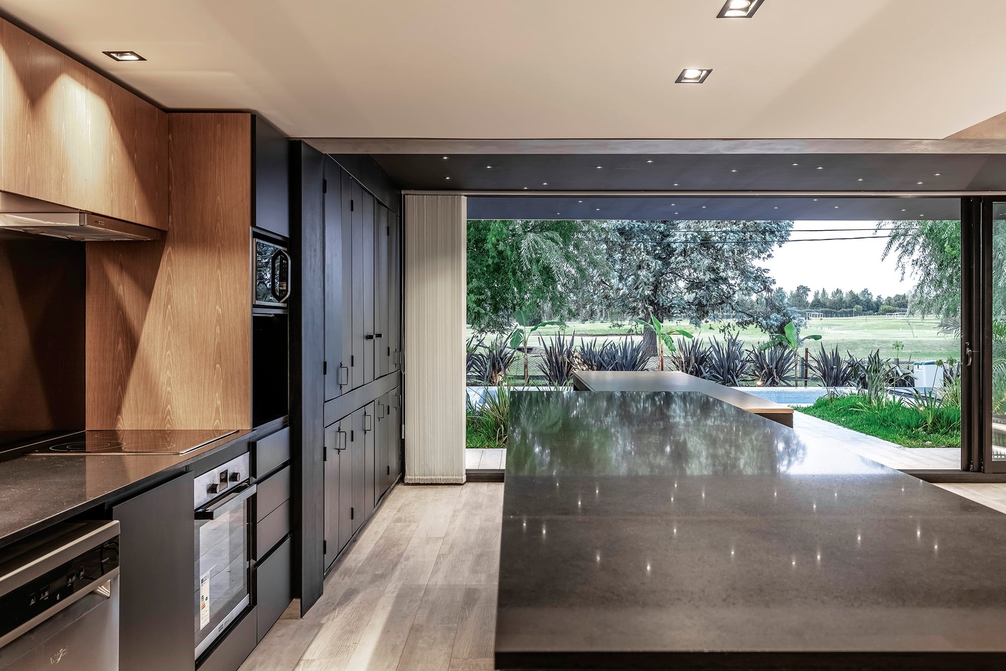 Mesadas de cuarzo en la cocina y la isla en color negro con acabado brillante