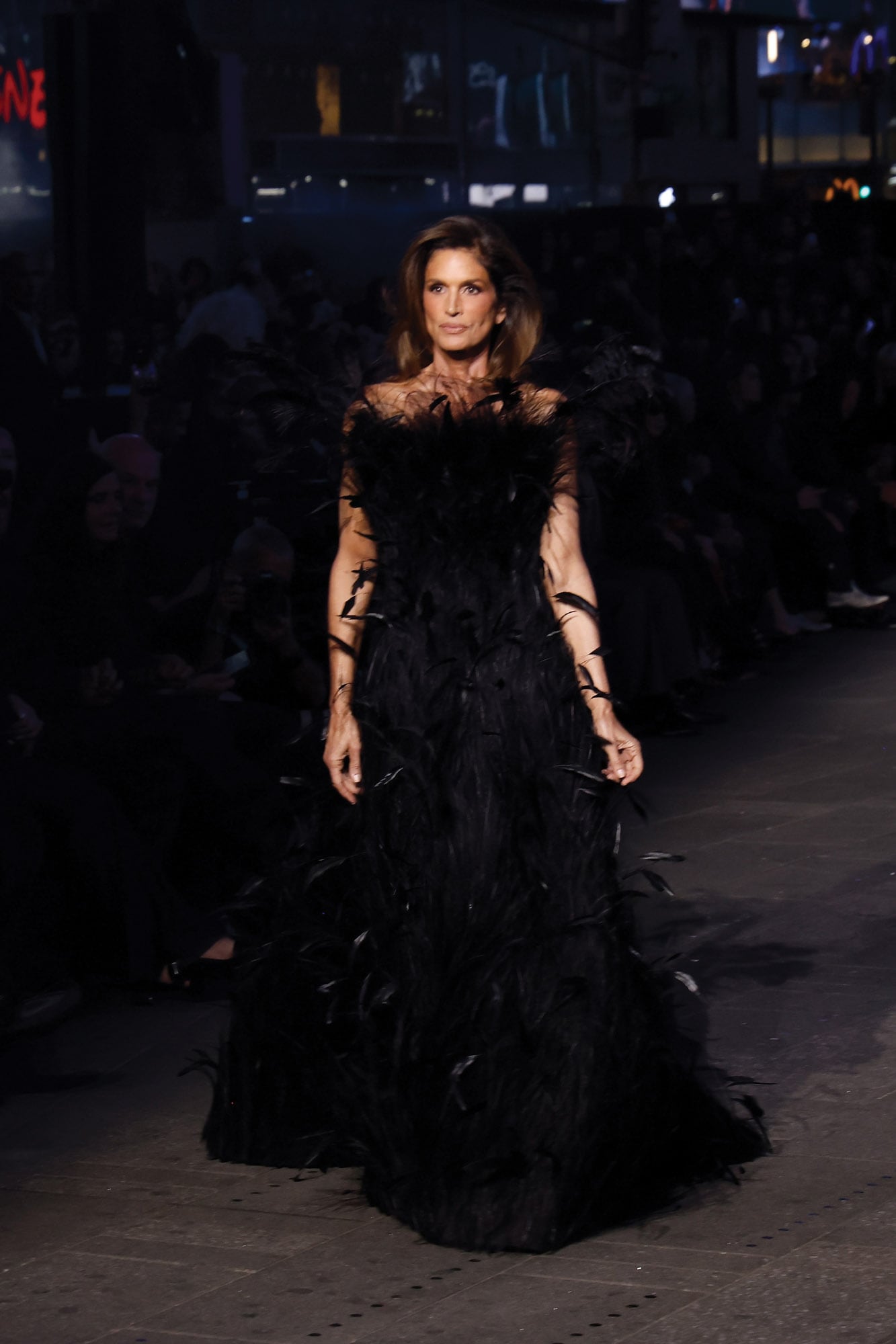 Cindy Crawford impactó con un strapless negro, de falda amplia, cubierto de plumas y lideró la lista de caras conocidas en el desfile 