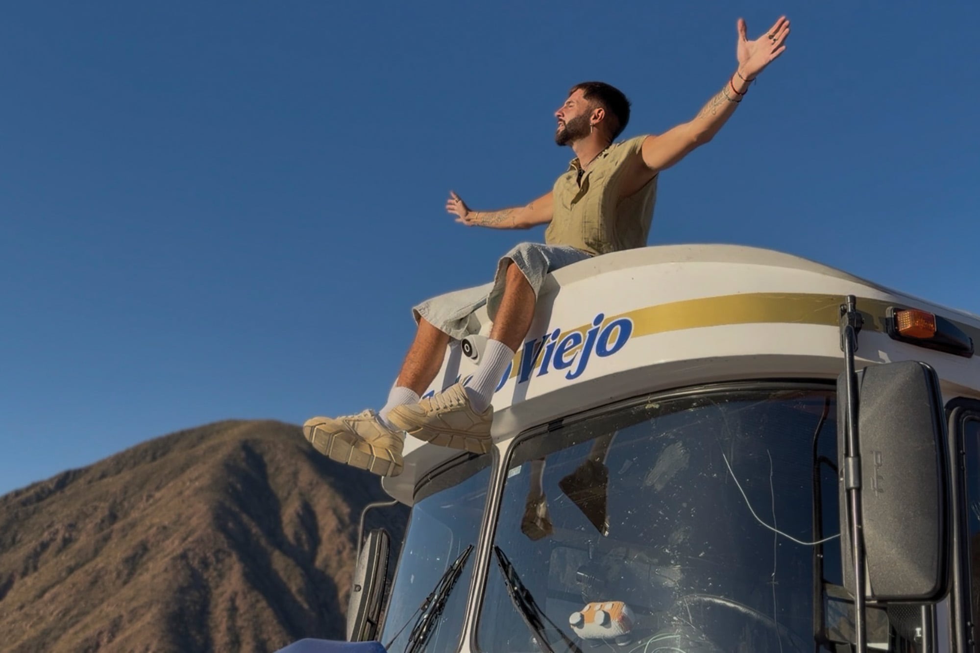 Sentado en el techo del motorhome, Benja disfruta de la naturaleza