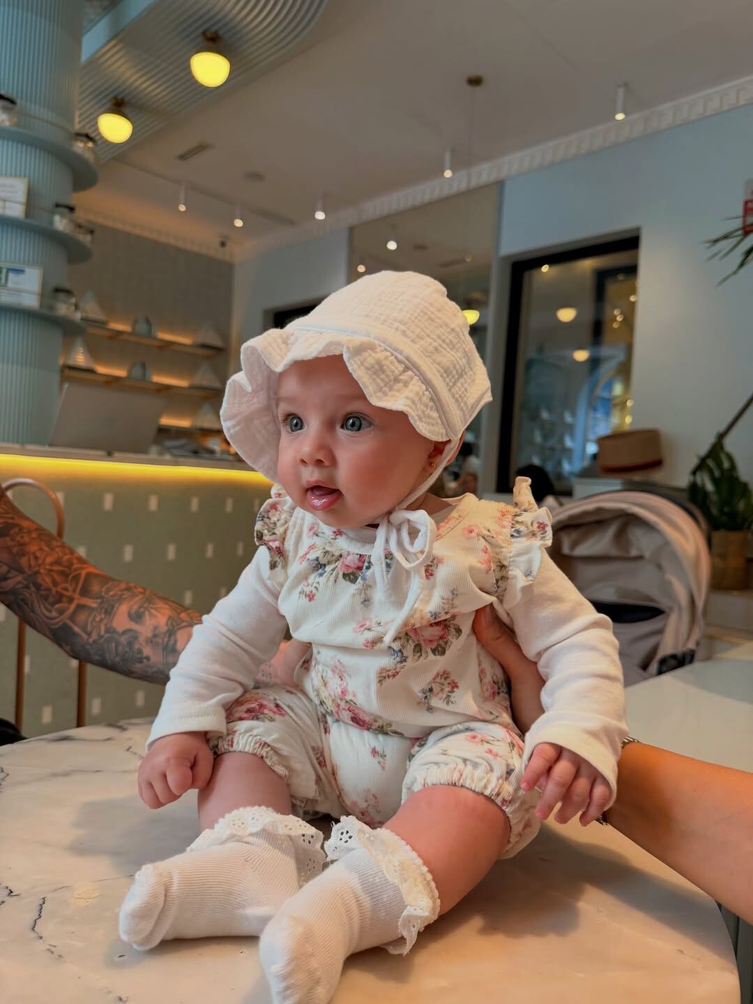 Aitana con un look tierno con flores estampadas y gorro estilo capelina Foto: @camihoms