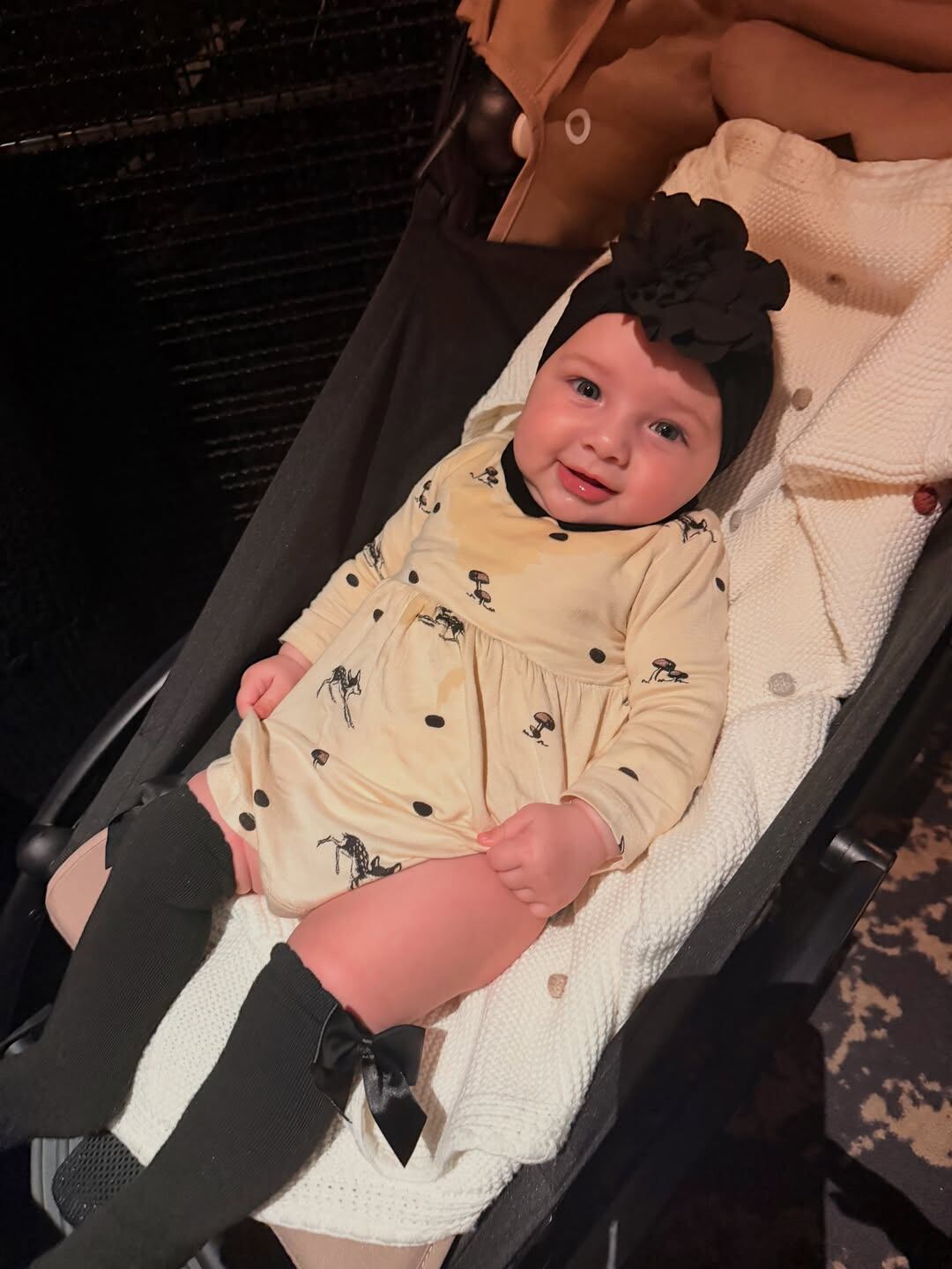 Aitana en su cochesito y sonriente, lució un mini vestido amarillo y turbante negro Foto: @camihoms