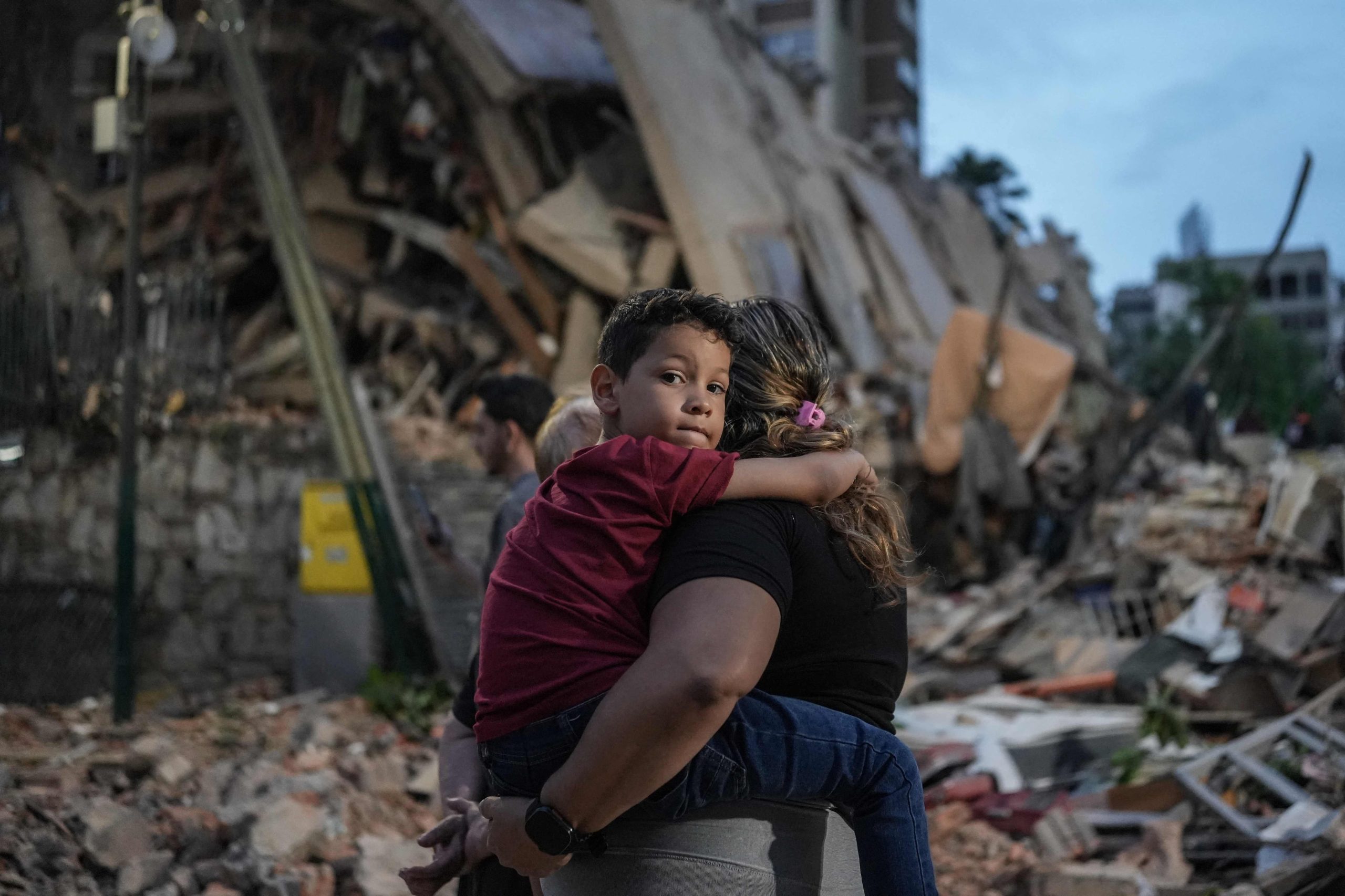 Unas personas pasan junto a un edificio derrumbado tras un terremoto en Caracas