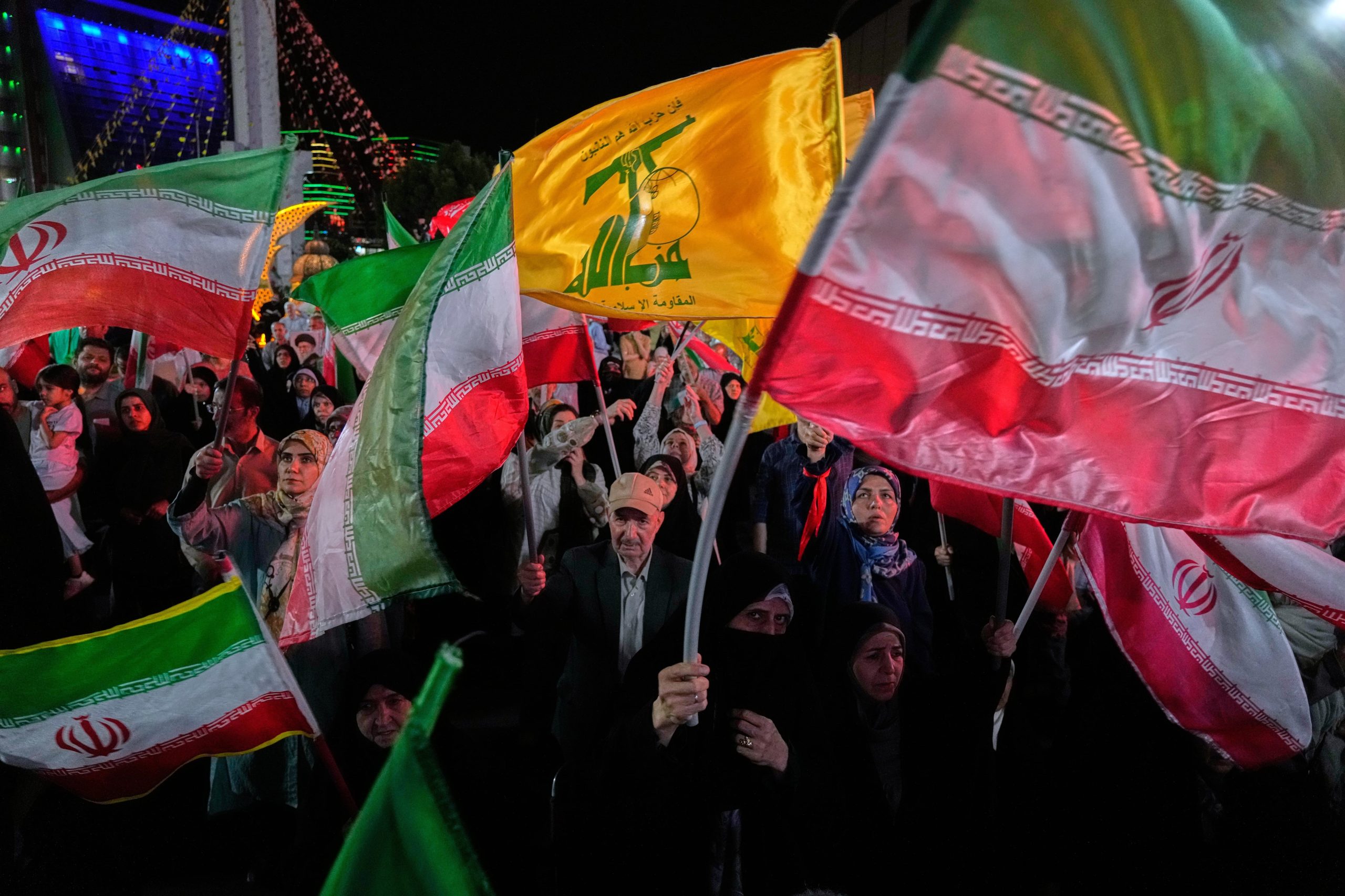 Manifestantes progubernamentales iraníes ondean las banderas de su país y las del grupo militante libanés Hezbollah en una concentración en Teherán