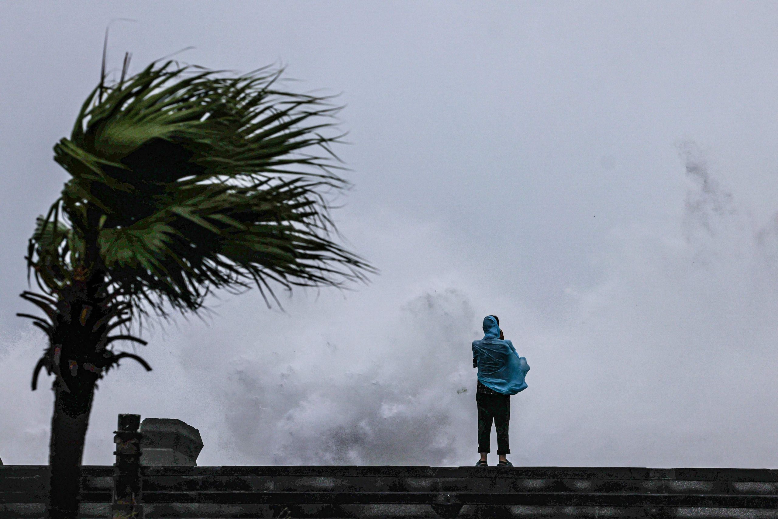 Una persona observa cómo grandes olas rompen contra la costa mientras el tifón Bavi pasa frente al noreste de Taiwán, en Keelung, el 11 de julio de 2026 (I-Hwa Cheng / AFP)