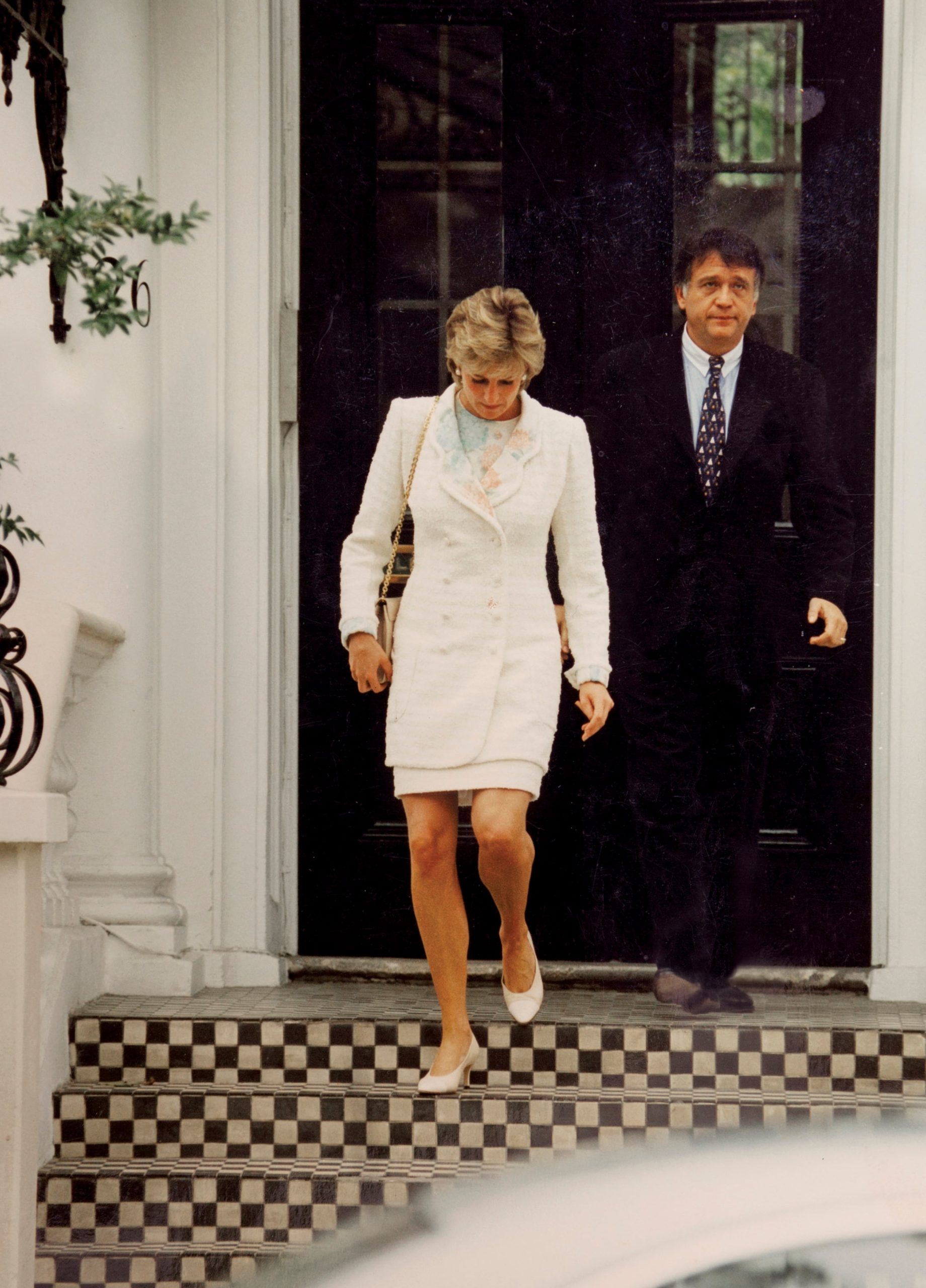 1 de mayo de 1996, la princesa de Gales (con tailleur de pollera y cartera Ferragamo) sale de la casa de Roberto Devorik en el número 26 de Holland Park, en Londres. La imagen se convirtió en una de las fotos más emblemáticas de aquella etapa de su vida: los fotógrafos la seguían sin tregua