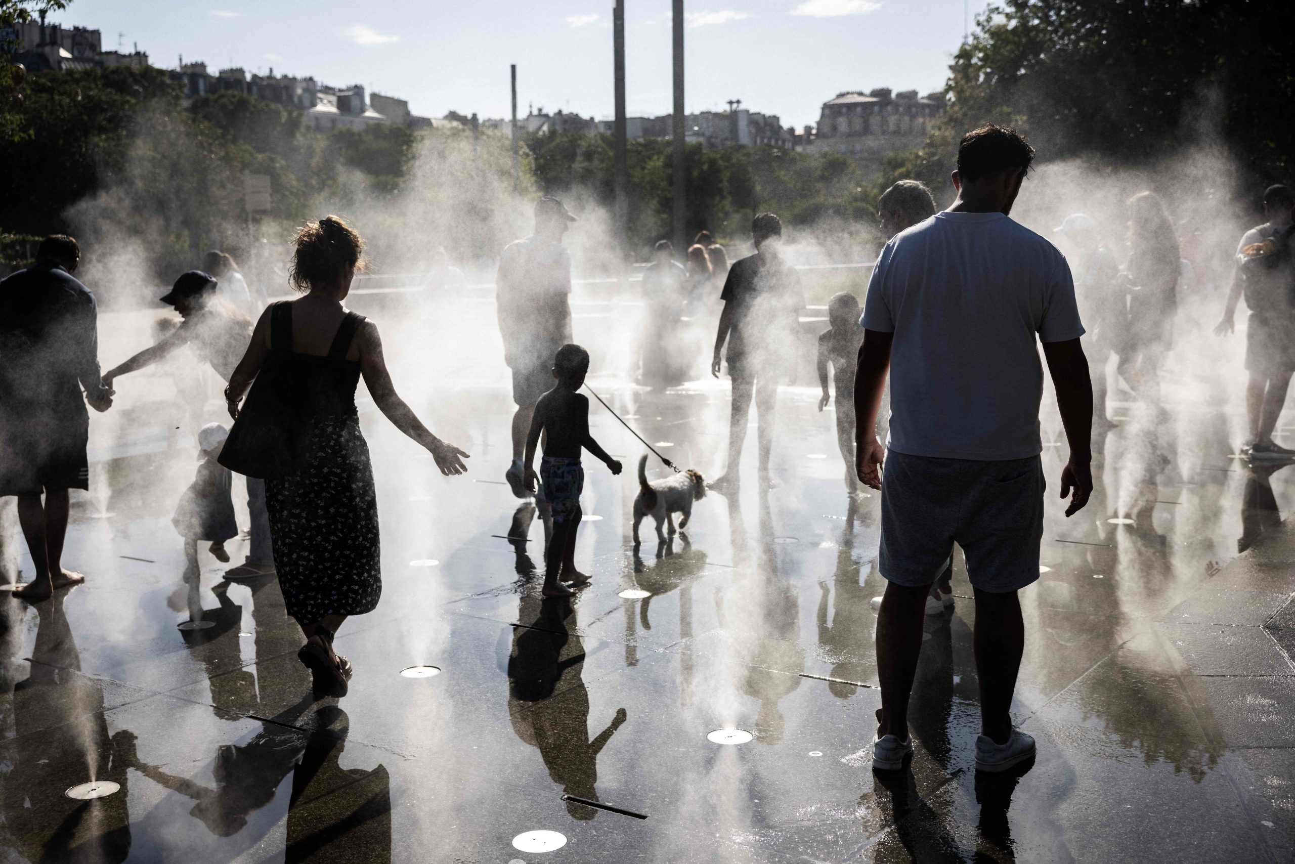 TOPSHOT - Children play in a splash pad during a heatwave in Paris on July 10, 2026. (Photo by Behrouz MEHRI / AFP)