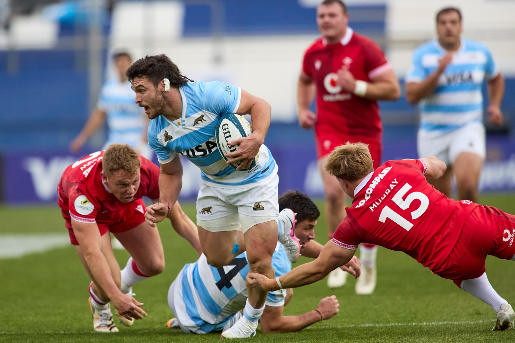 Mateo Carreras intenta evitar dos tackles; los Pumas han sido superiores a los galeses en la etapa inicial del encuentro en San Juan por el Nations Championship.