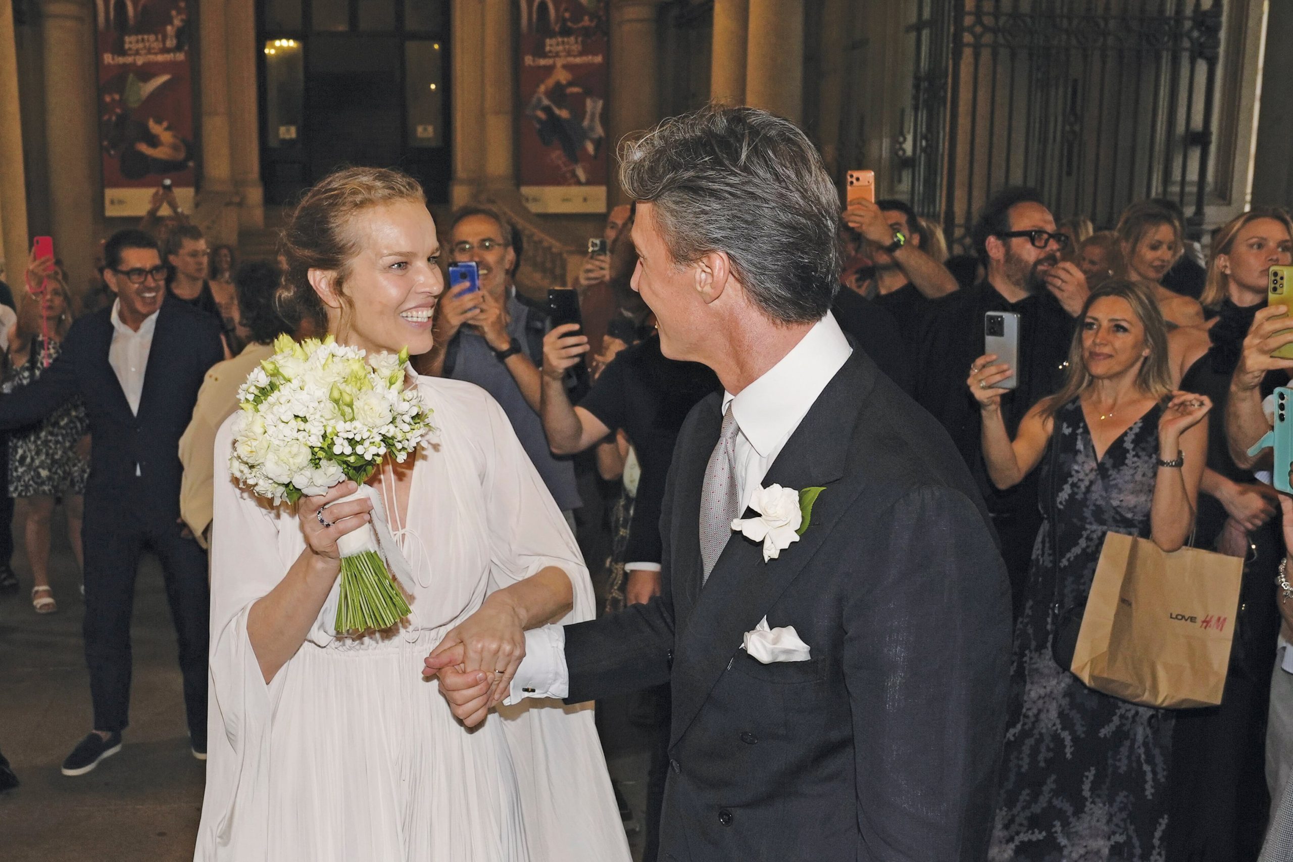 Giorgio lució un impecable traje oscuro con un boutonnière blanco a juego con el bouquet de su mujer