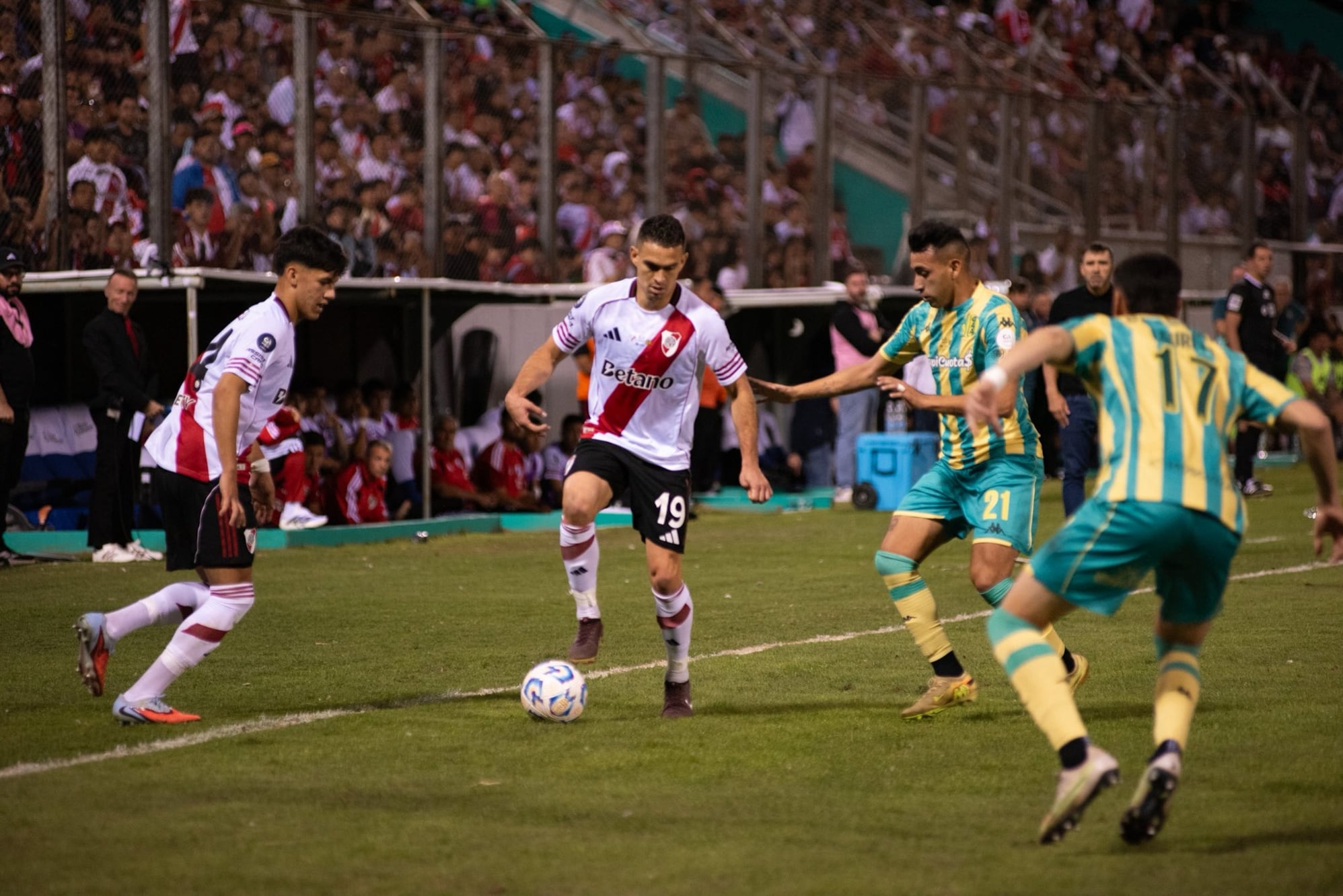 Rafael Santos Borré lleva la pelota ante la marca de Matías Godoy