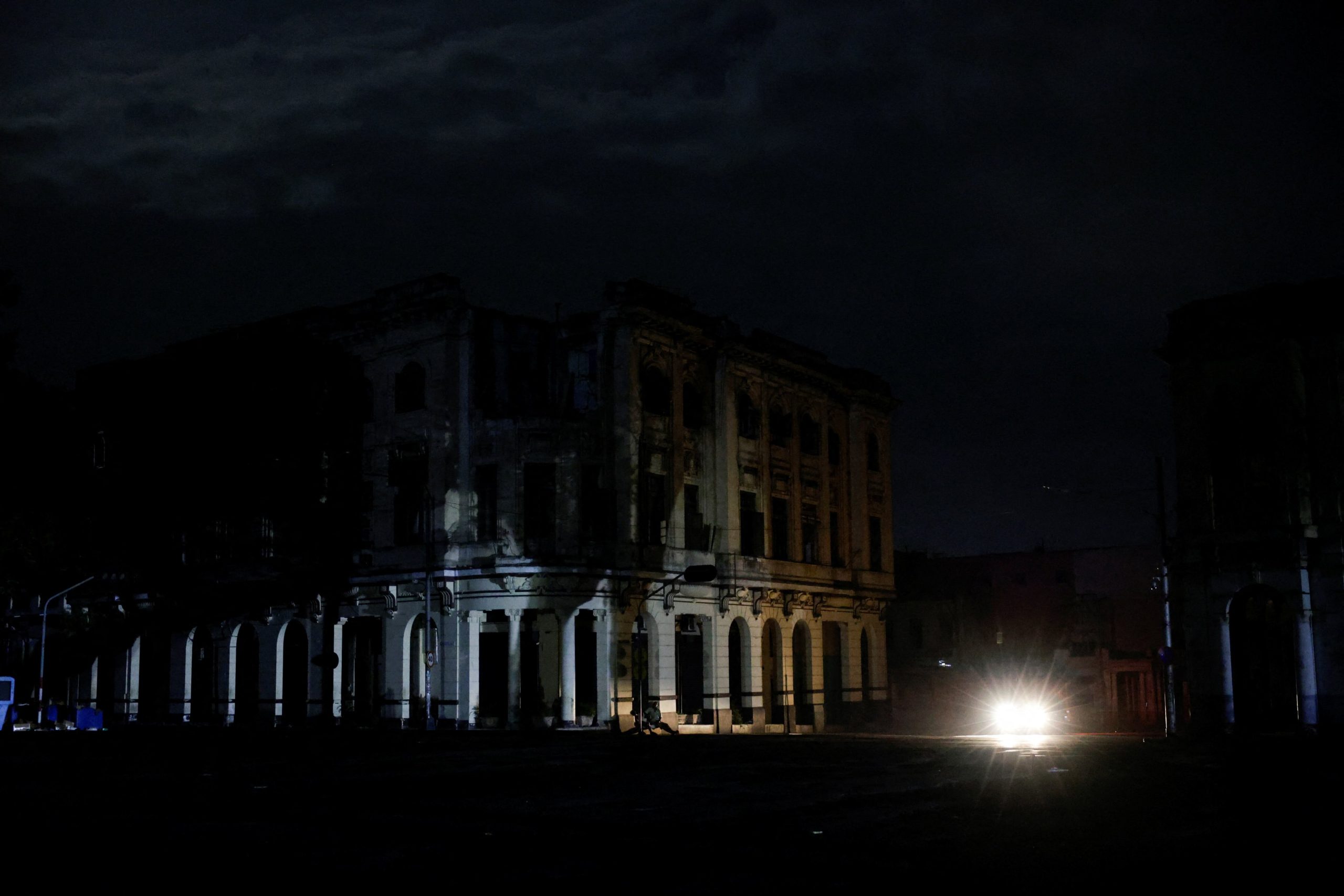 Un auto ilumina la fachada de un edificio durante el apagón nacional en Cuba. (Foto: Reuters/Norlys Pérez).