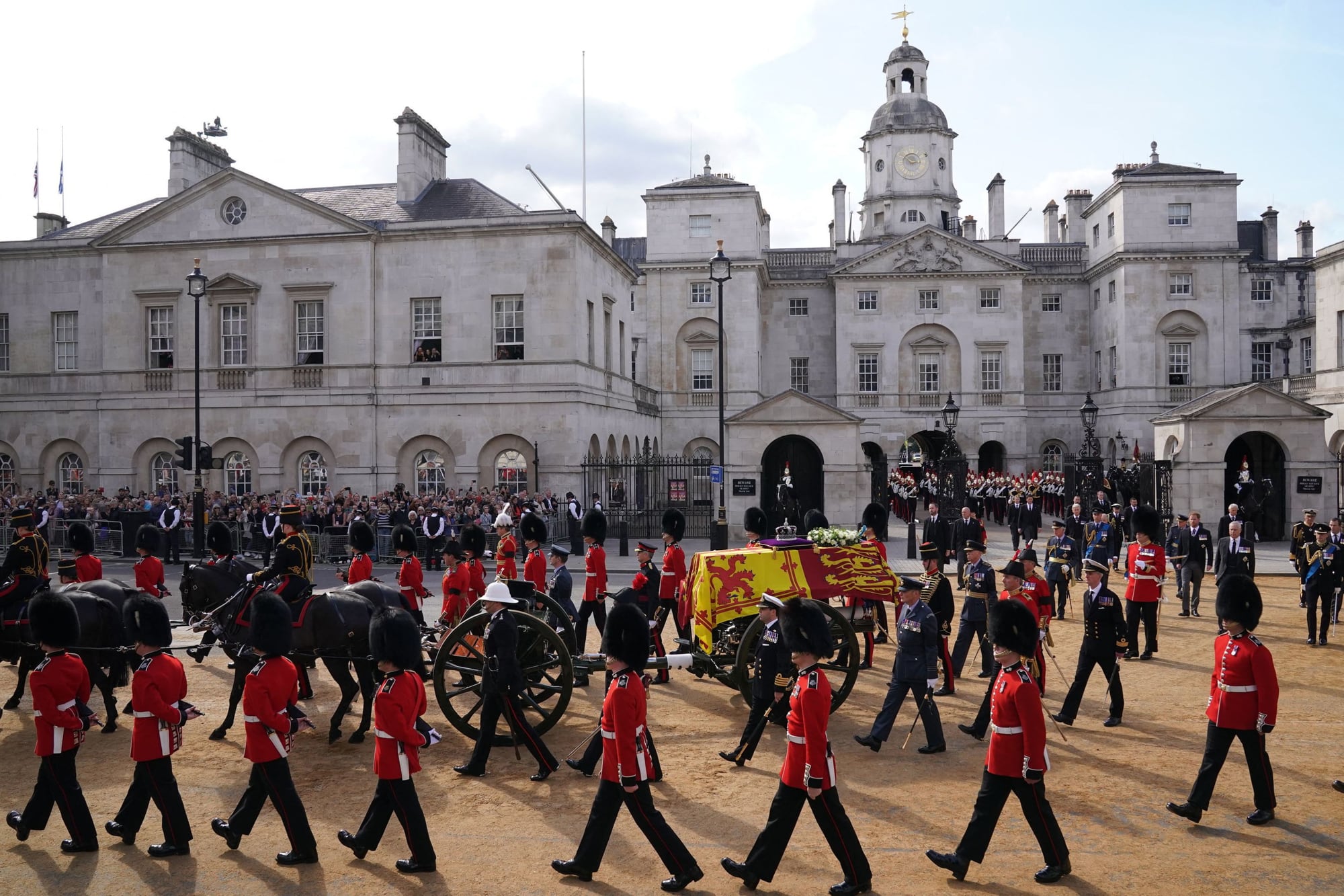 El féretro de la reina Isabel II, cubierto con el Estandarte Real y coronado por la Corona Imperial del Estado, es trasladado en una cureña de la Artillería Real a Caballo de la Tropa del Rey mientras atraviesa Horse Guards Parade, durante la procesión desde el Palacio de Buckingham hasta el Palacio de Westminster (Photo by Kirsty O'Connor / POOL / AFP)