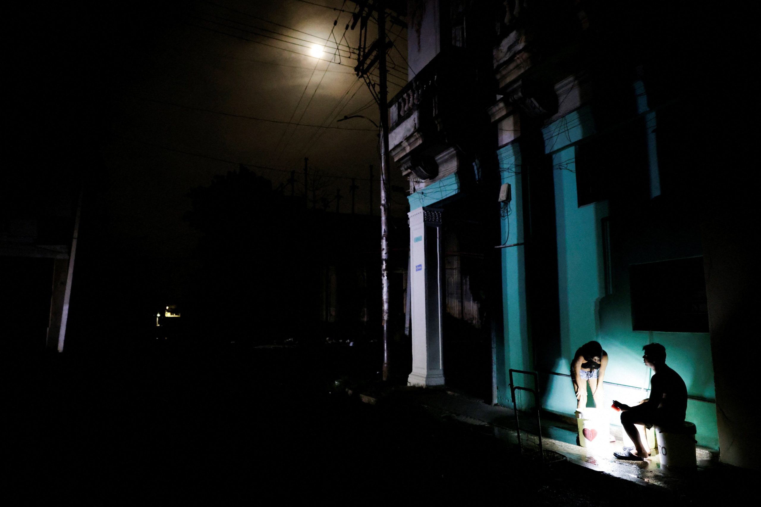 Daimel Rodríguez y su esposa juntan agua potable tras el apagón nacional en Cuba. (Foto: Reuters/Norlys Pérez)