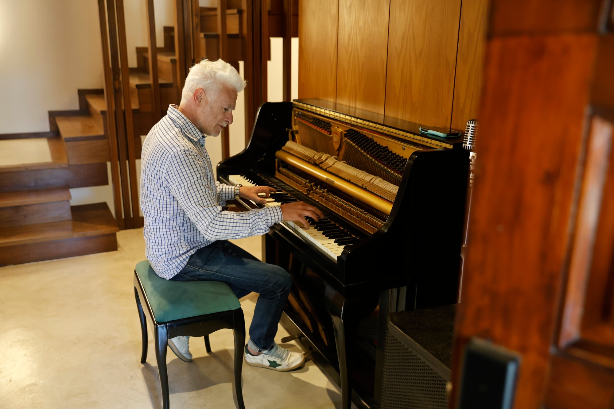 En la entrada de la casa se encuentra un micrófono retro, un piano vertical y parlantes, ya que es la sede de las prácticas de la banda del médico