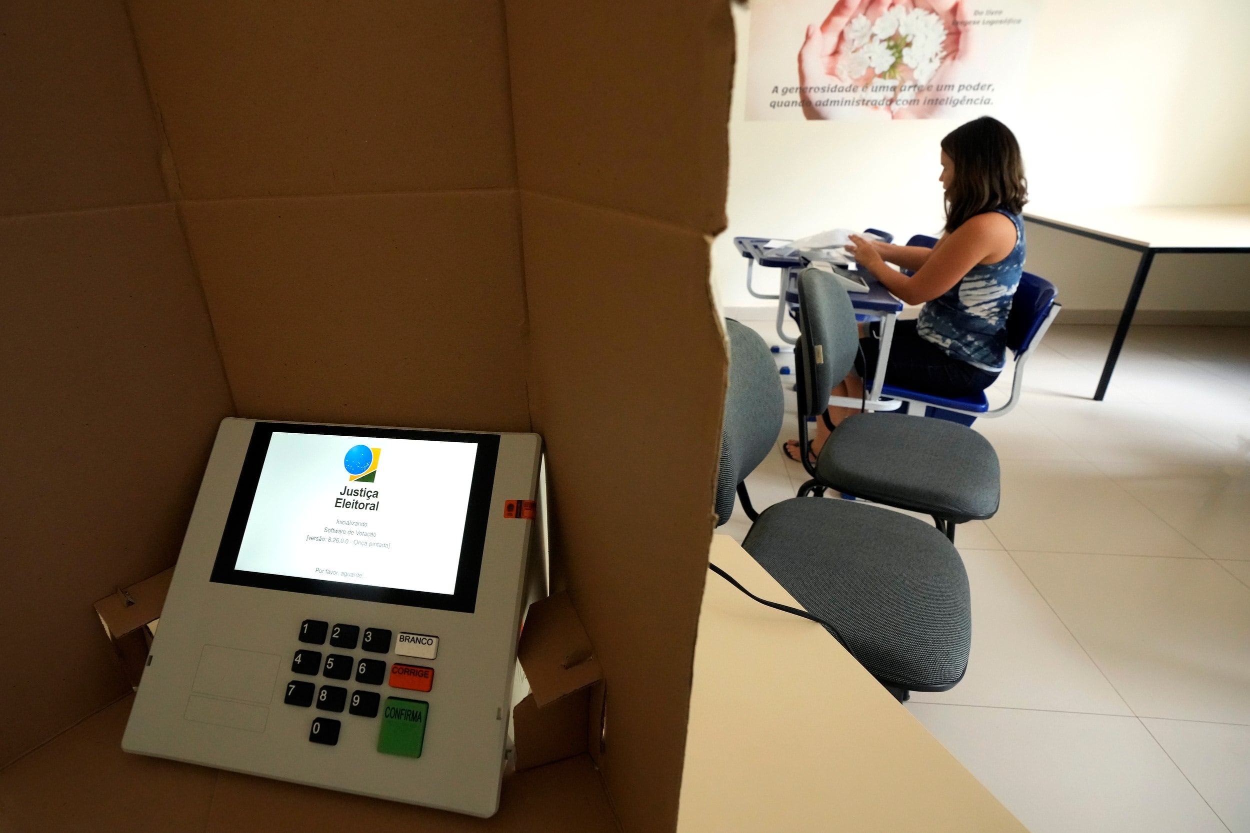 Una trabajadora instala una máquina de voto electrónico durante los preparativos para el balotaje en Brasil