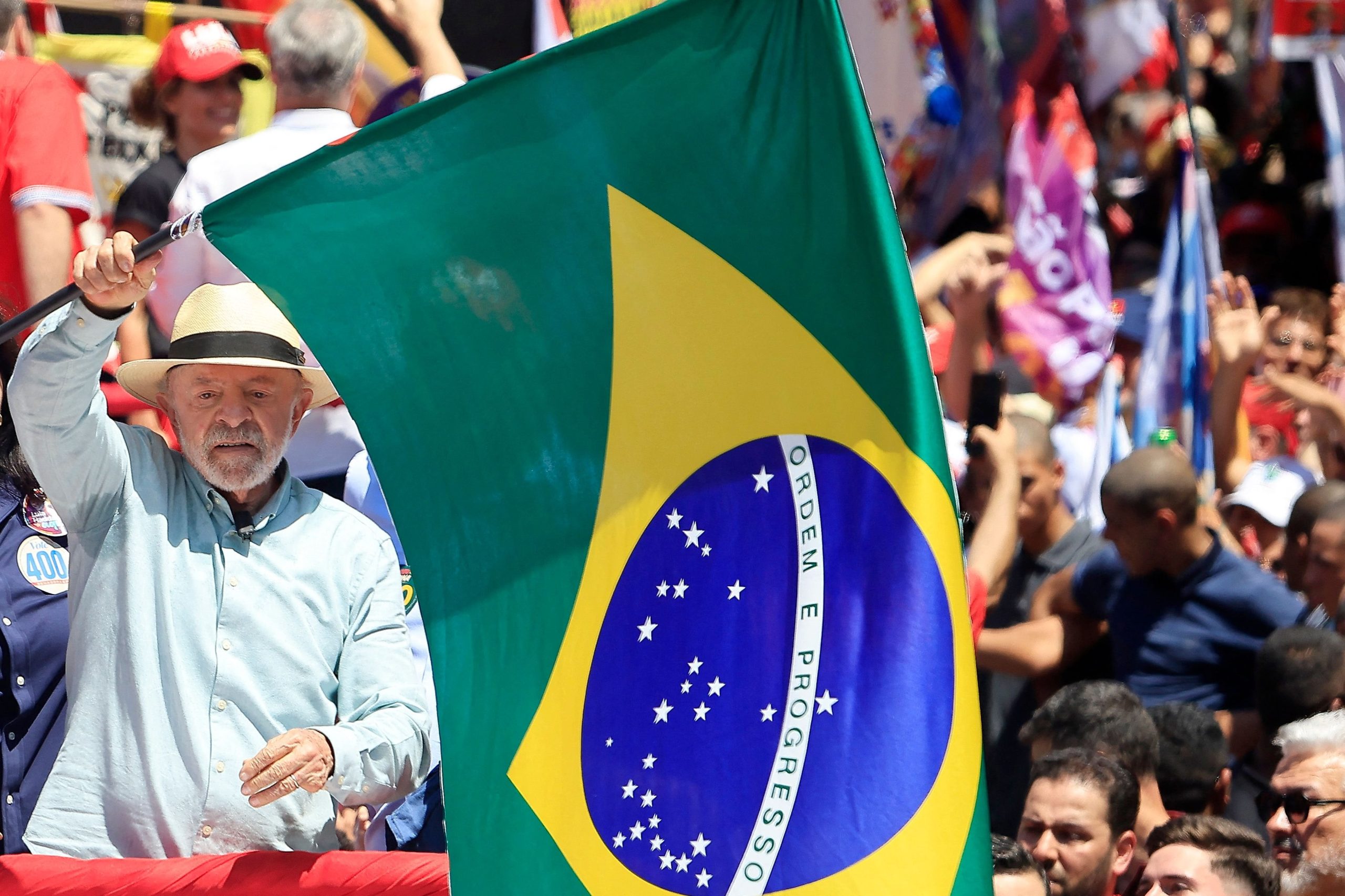 El presidente de Brasil y candidato presidencial, Luiz Inácio Lula da Silva, ondea una bandera nacional durante un acto de campaña en el barrio de São Miguel Paulista