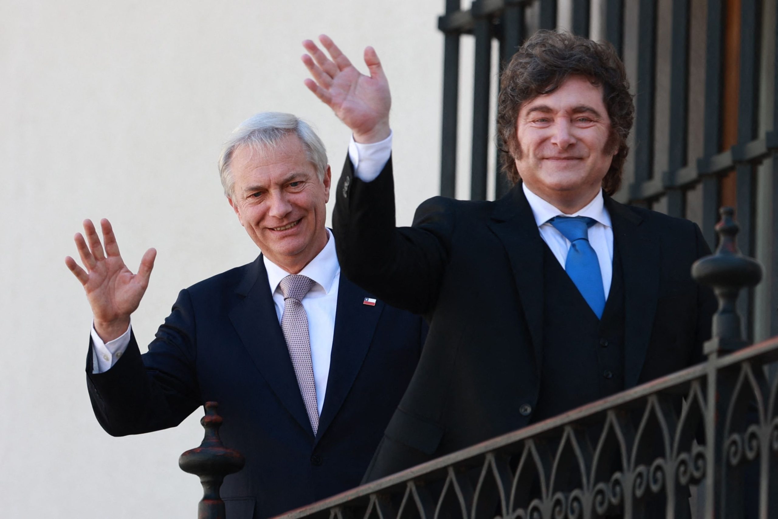 Kast y Milei saludan desde un balcón del Palacio de La Moneda durante una ceremonia de bienvenida en Santiago