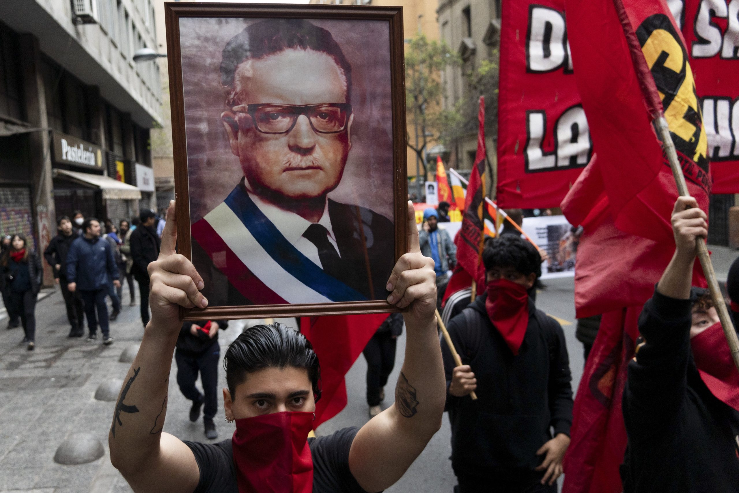 Un hombre que sostiene una fotografía del difunto presidente de Chile, Salvador Allende, participa en una manifestación que conmemora el 50 aniversario de un golpe militar liderado por el general Augusto Pinochet en Santiago