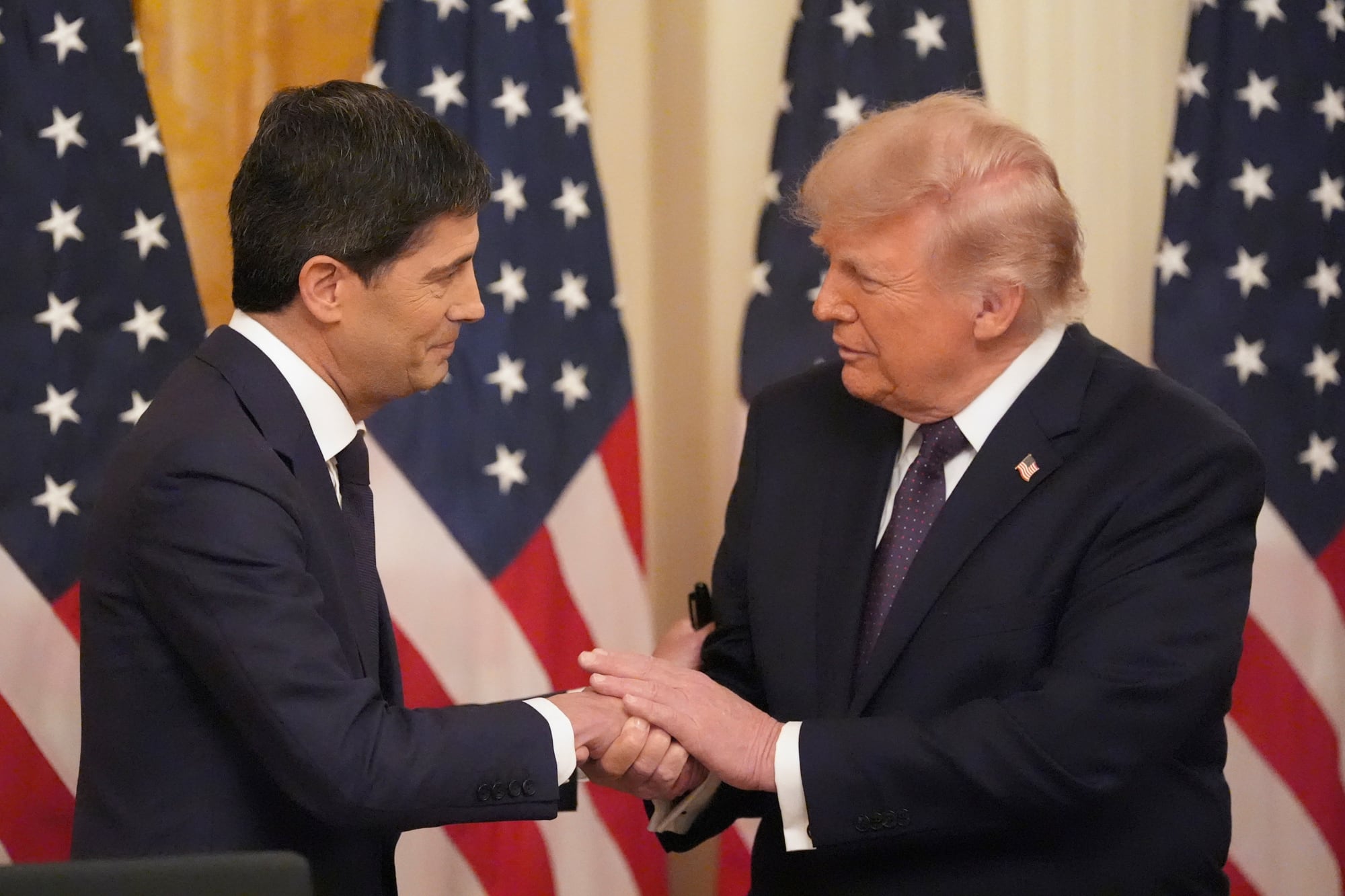 Trump estrecha la mano del presidente de la Reserva Federal, Kevin Warsh, durante la toma de posesión de este último en el Salón Este de la Casa Blanca