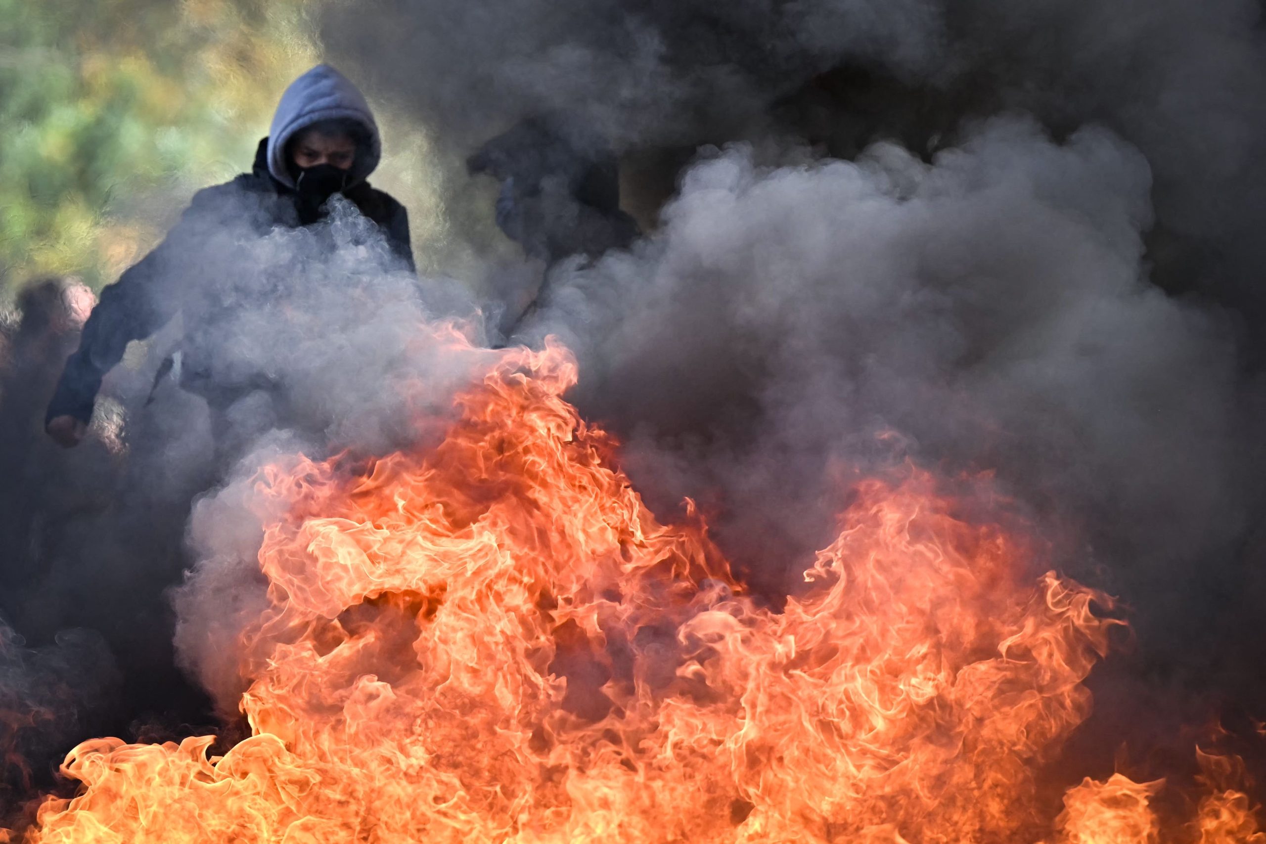 Un manifestante permanece junto al fuego de una barricada en llamas mientras estudiantes participan de una acción de bloqueo frente a la escuela secundaria Le Corbusier, en Aubervilliers, al norte de París