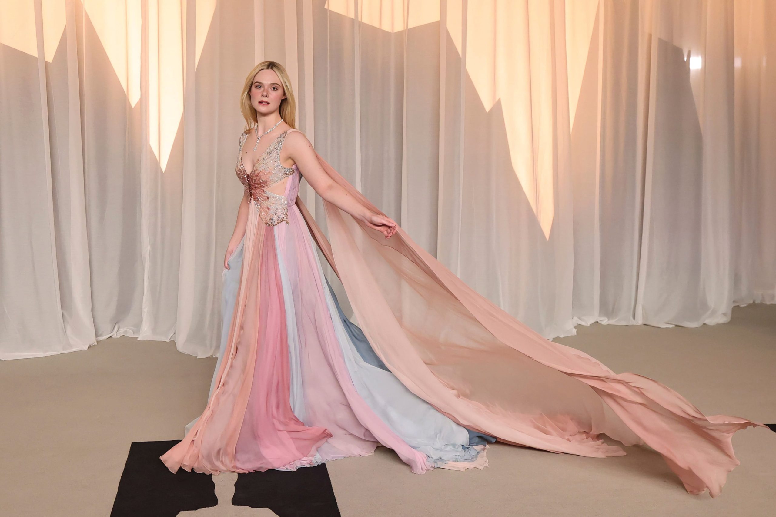 Elle Fanning elevó el romanticismo a un terreno casi fantástico con un vestido de Valentino, cuyo cuerpo tomó la forma de una mariposa mientras una capa fluida acompañaba el movimiento. Lo complementó con alhajas Cartier