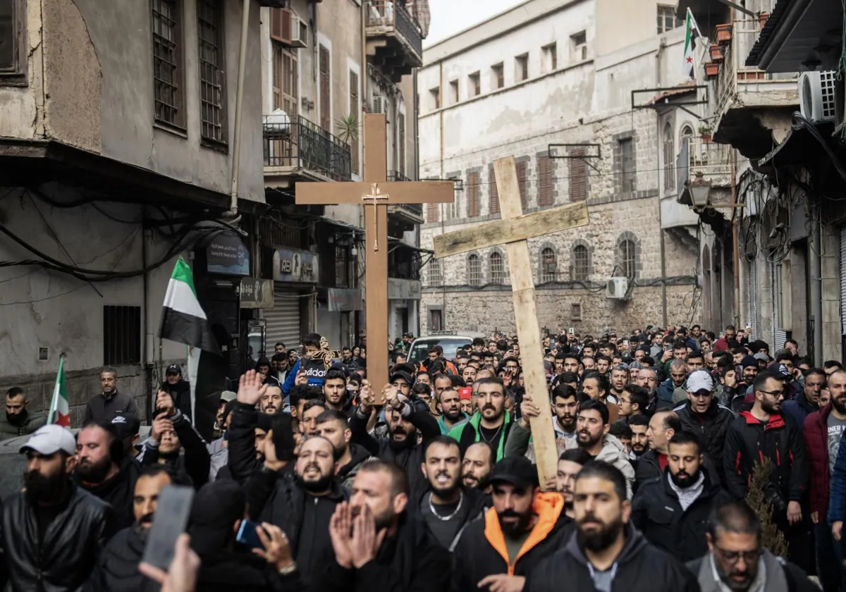 Portando cruces, manifestantes cristianos protestan en Damasco contra la quema de un árbol de Navidad