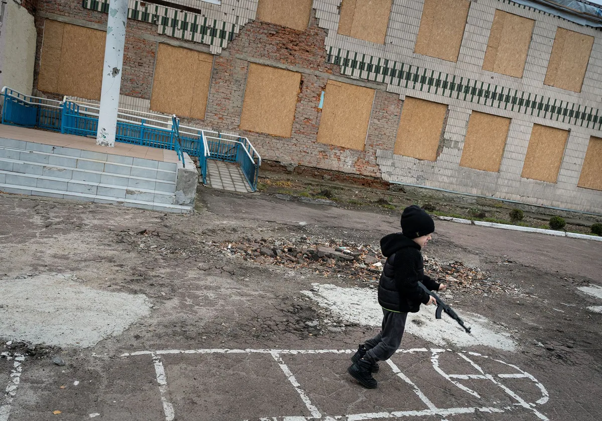 Luka corretea con un fusil de juguete mientras se construye una escuela subterránea cerca del frente