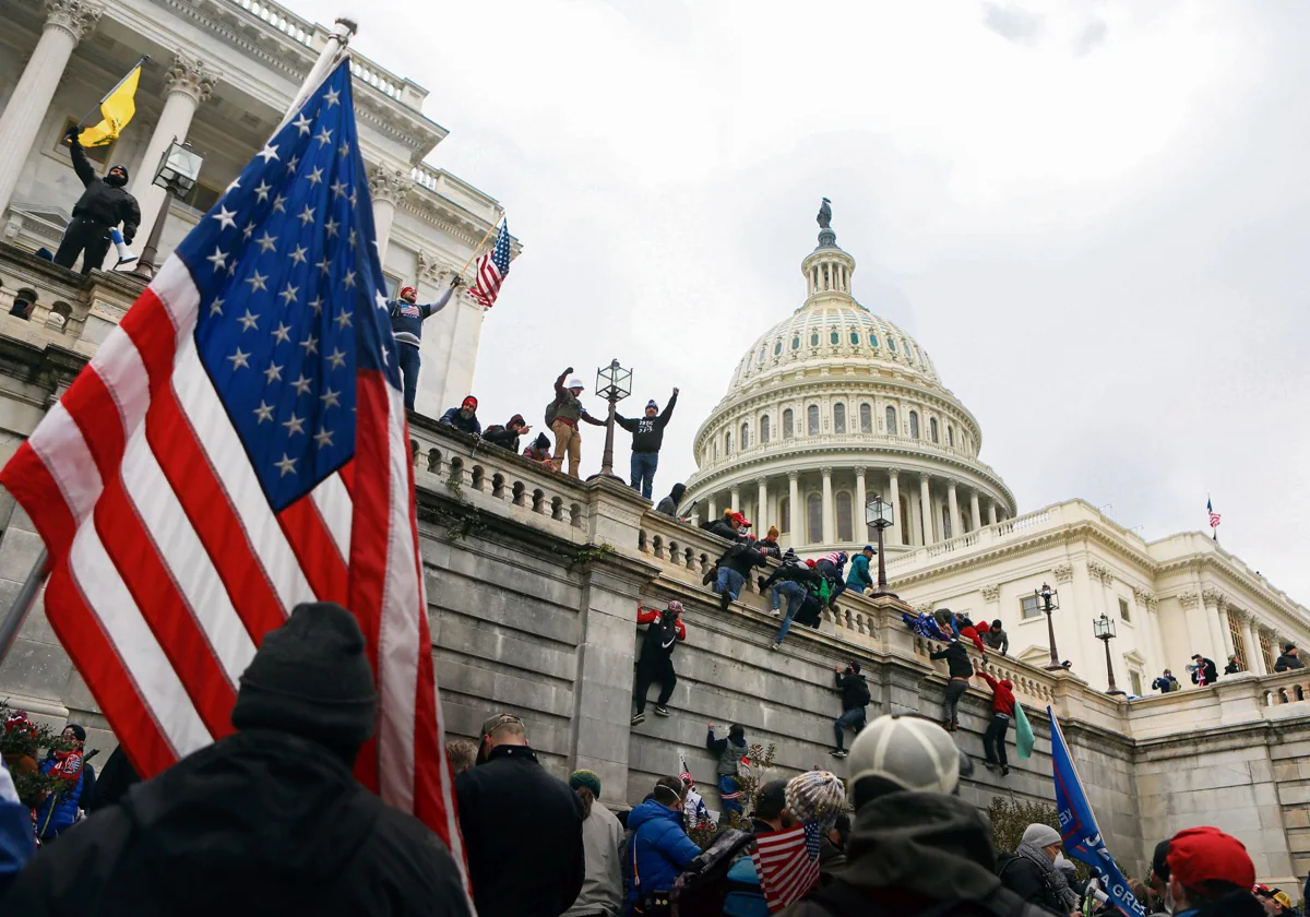 Partidarios del presidente estadounidense Donald Trump trepan a los muros del Capitolio de Estados Unidos el 6 de enero de 2021