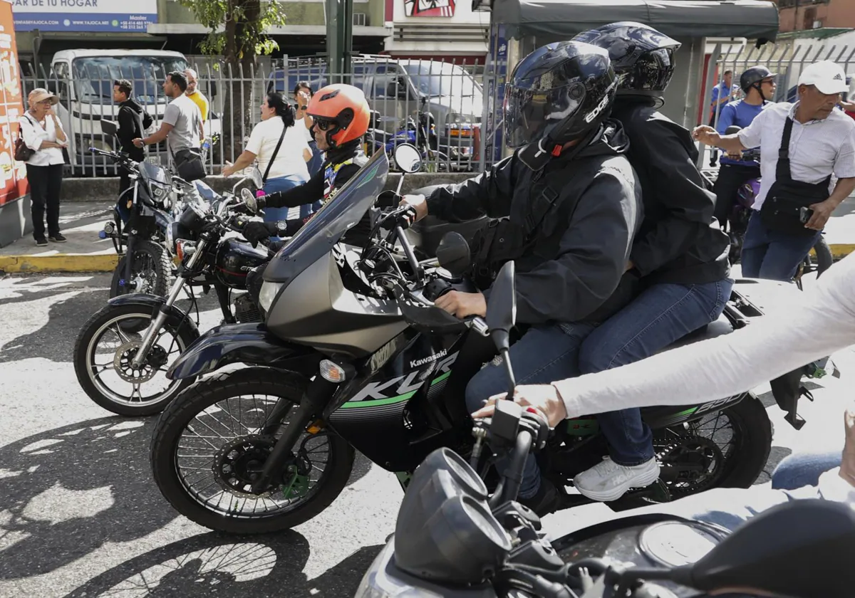 La líder antichavista María Corina Machado (c-d, casco negro) se retira de una manifestación este jueves, en Caracas