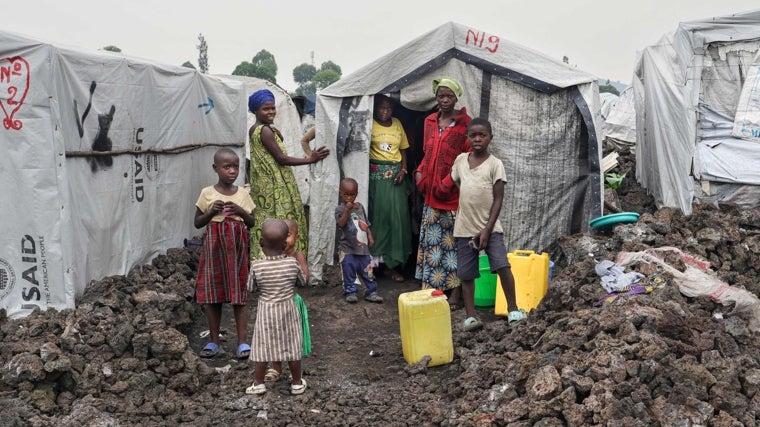 Mujeres y niños son fotografiados frente a sus refugios improvisados en un campamento para desplazados en el Congo